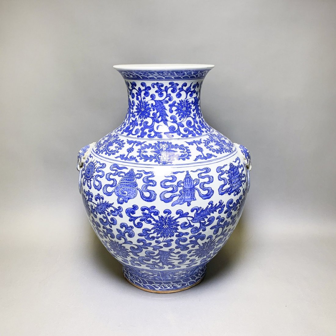 A BLUE AND WHITE 'LOTUS AND BAJIXIANG' ZUN VASE: A blue and white 'lotus and bajixiang' zun vase, the vase is brightly painted in shades of cobalt blue with similated 'heaping and pilling' to depict the Eight Buddhist Emblems, bajixiang, above large