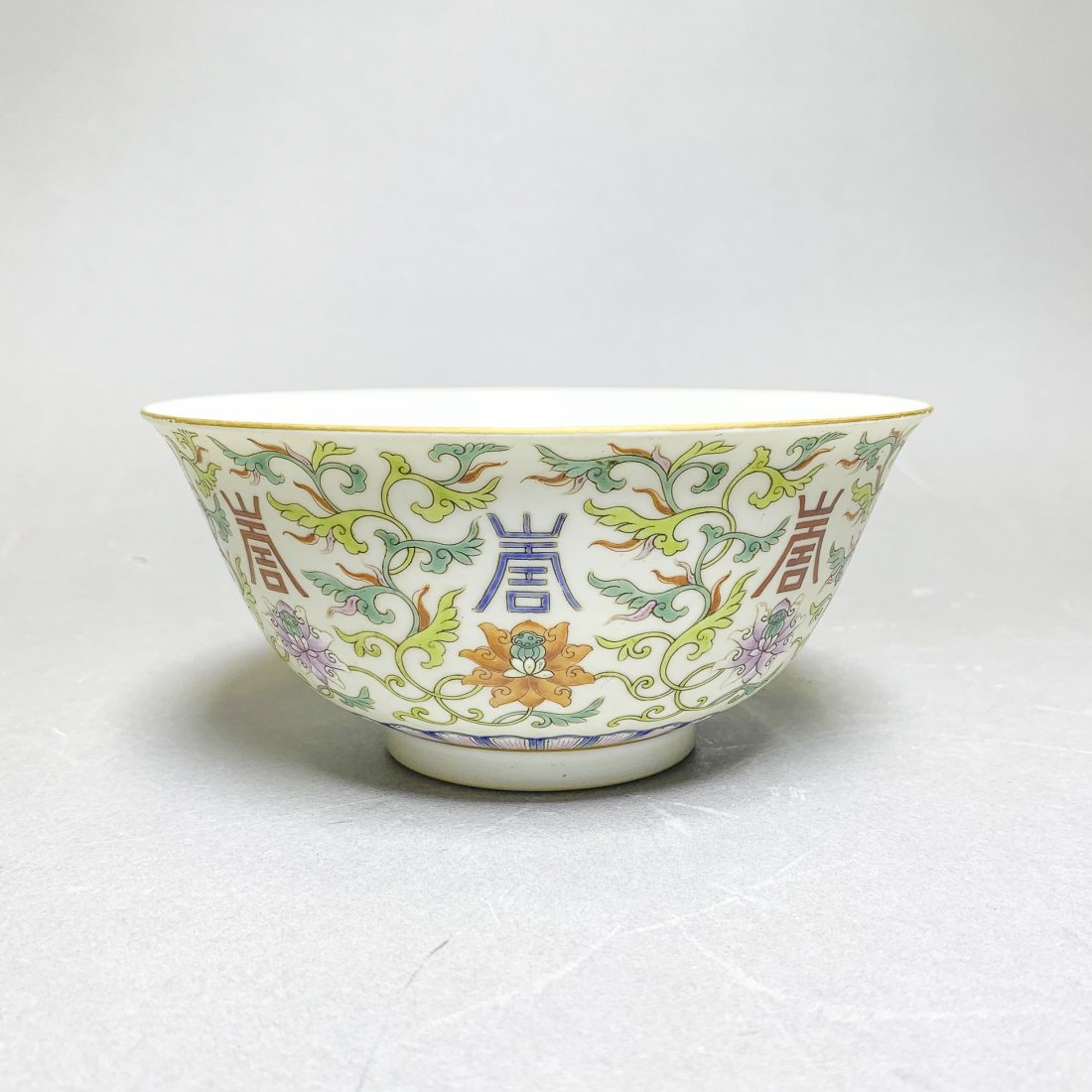 A FAMILLE ROSE BOWL, XIANFENG MARK, REPUBLIC PERIOD: A famille rose bowl, xianfeng mark. With deep, slightly flaring sides, painted on the exterior with foliage interspersed with lotus, the interior decorated in iron red with five bats (wufu) in flight.