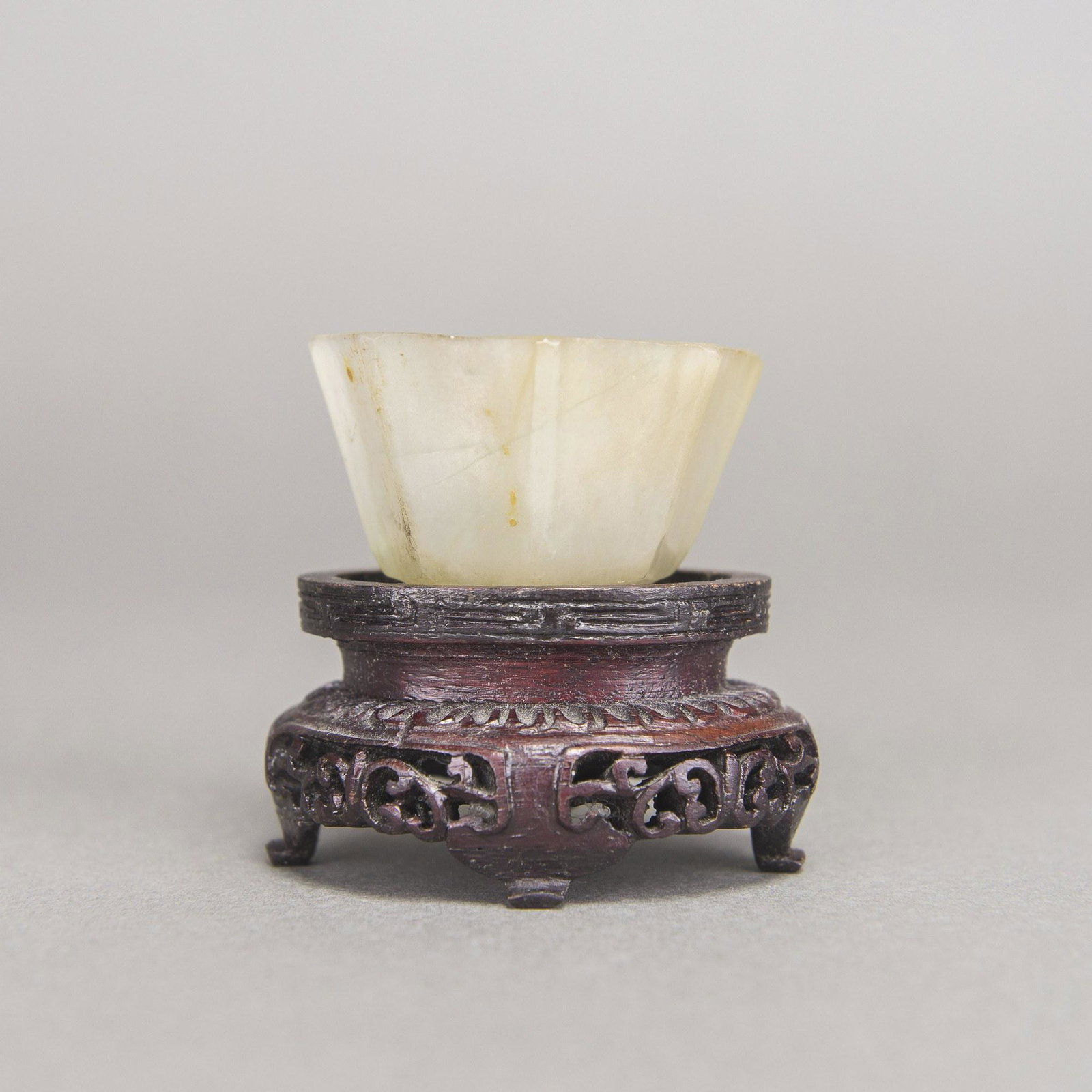 A WHITE JADE OCTAGONAL BRUSH WASHER: A white jade octagonal brush washer, with a wooden stand. 4.5x3cm (without stand)