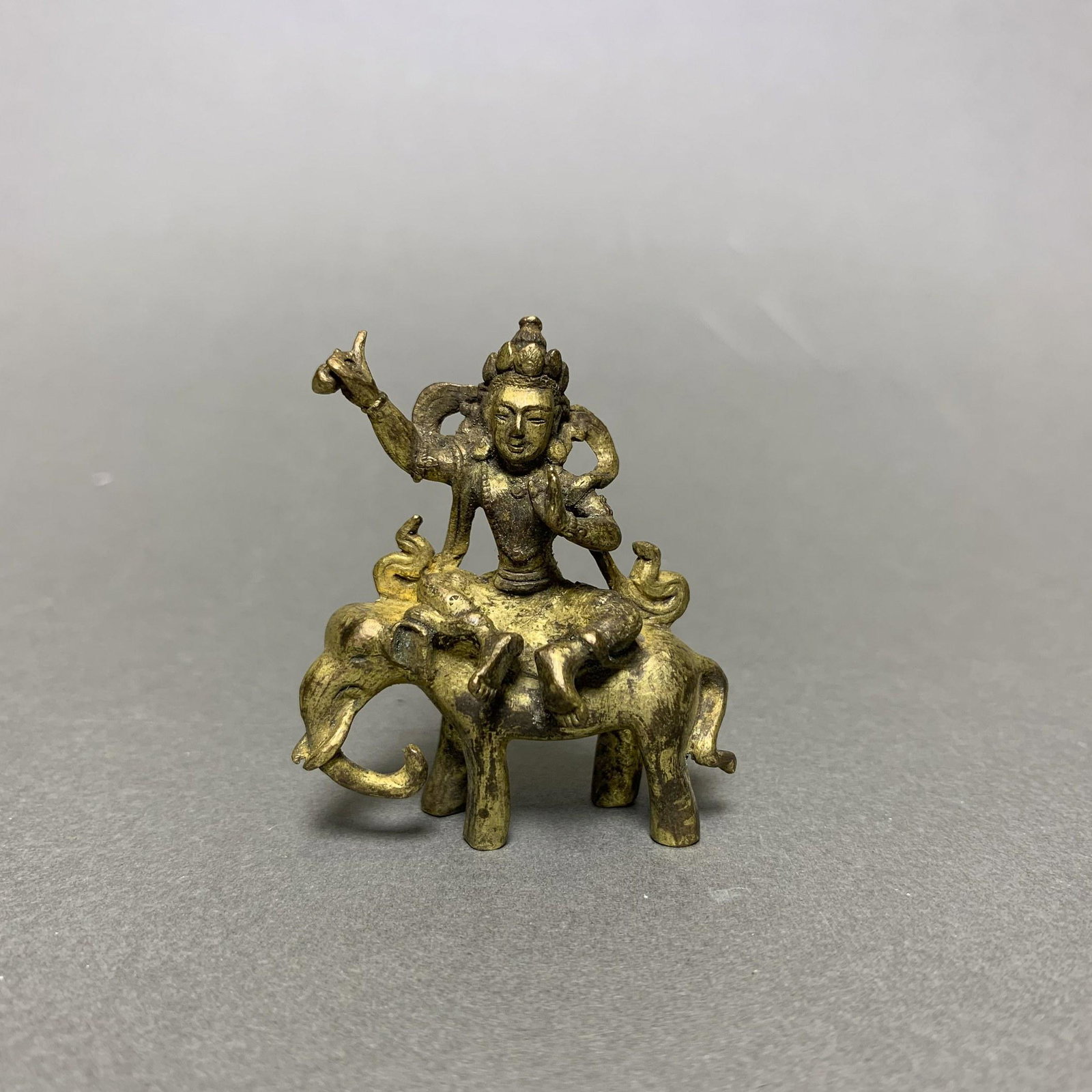 A GILT BRONZE FIGURE OF BUDDHA: A gilt-bronze buddha, cast of a buddha seating on an elephant. 4.5 x 5.5 cm