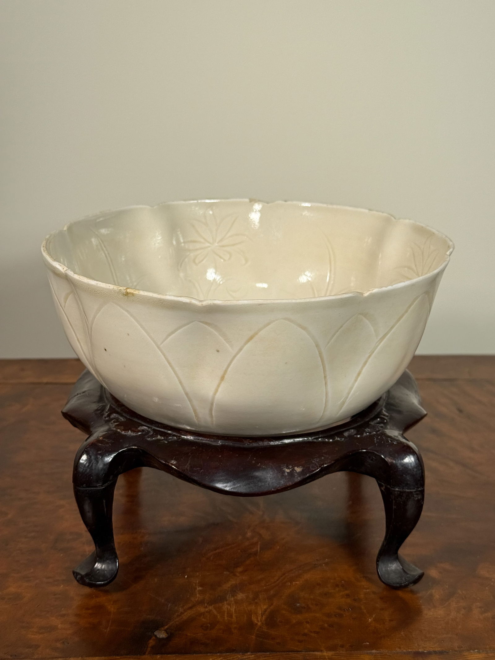 JAPANESE STUDIO PORCELAIN BOWL WITH INCISED FISH MOTIF: Japanese studio porcelain bowl with incised fish design, with lacquered wood stand. Bowl rim is unglazed, possibly had silver rim but lost in the past age. Dimensions: Bowl: Diameter: 7.75 in.