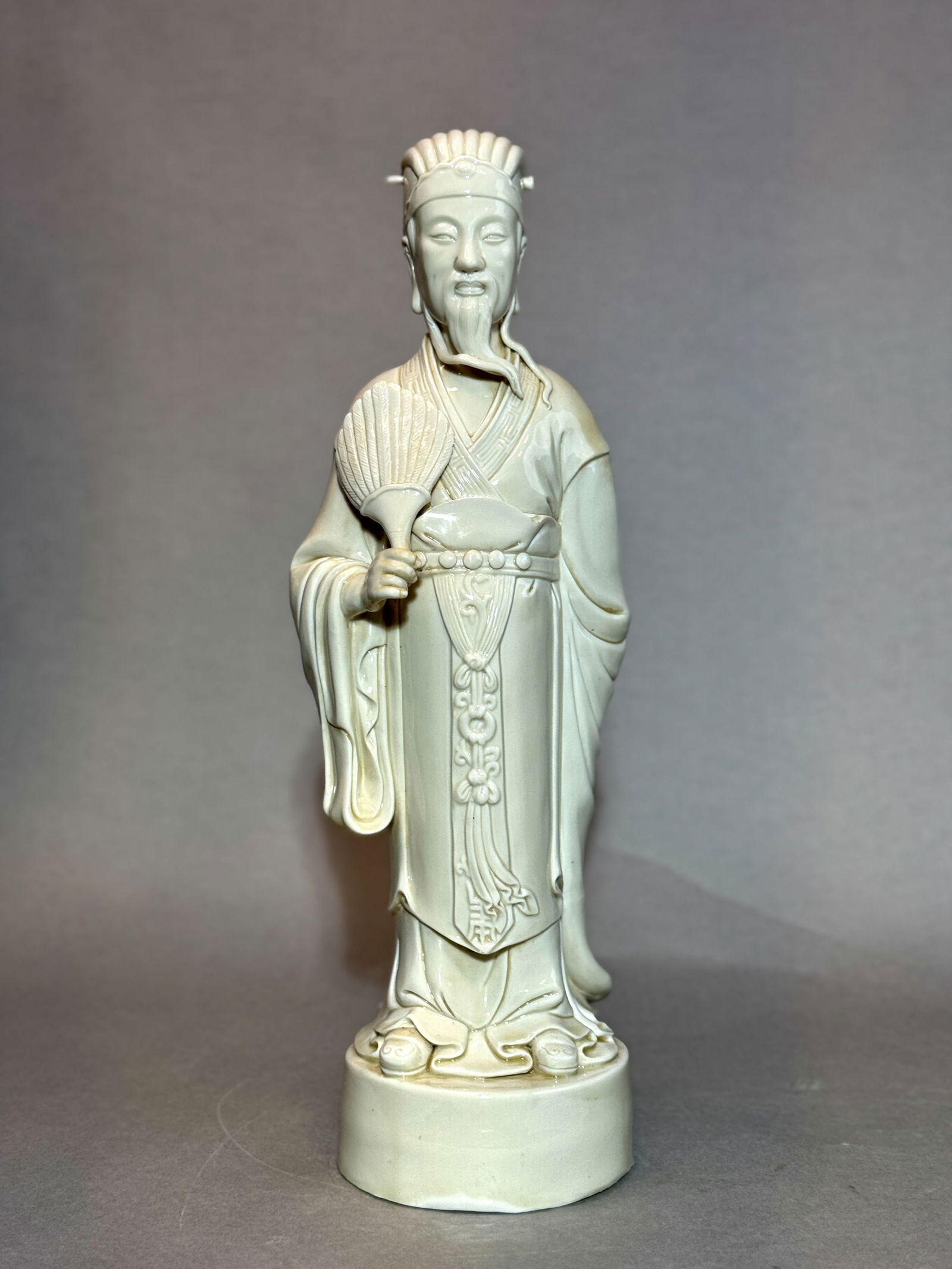 CHINESE DEHUA PORCELAIN SCHOLAR WITH FAN: Chinese Dehua porcelain scholar with fan, 19th/20th century. Signed with impressed seal. Dimensions: Height: 17.5 in. Note: This item is in New York, where it can be shipped from.