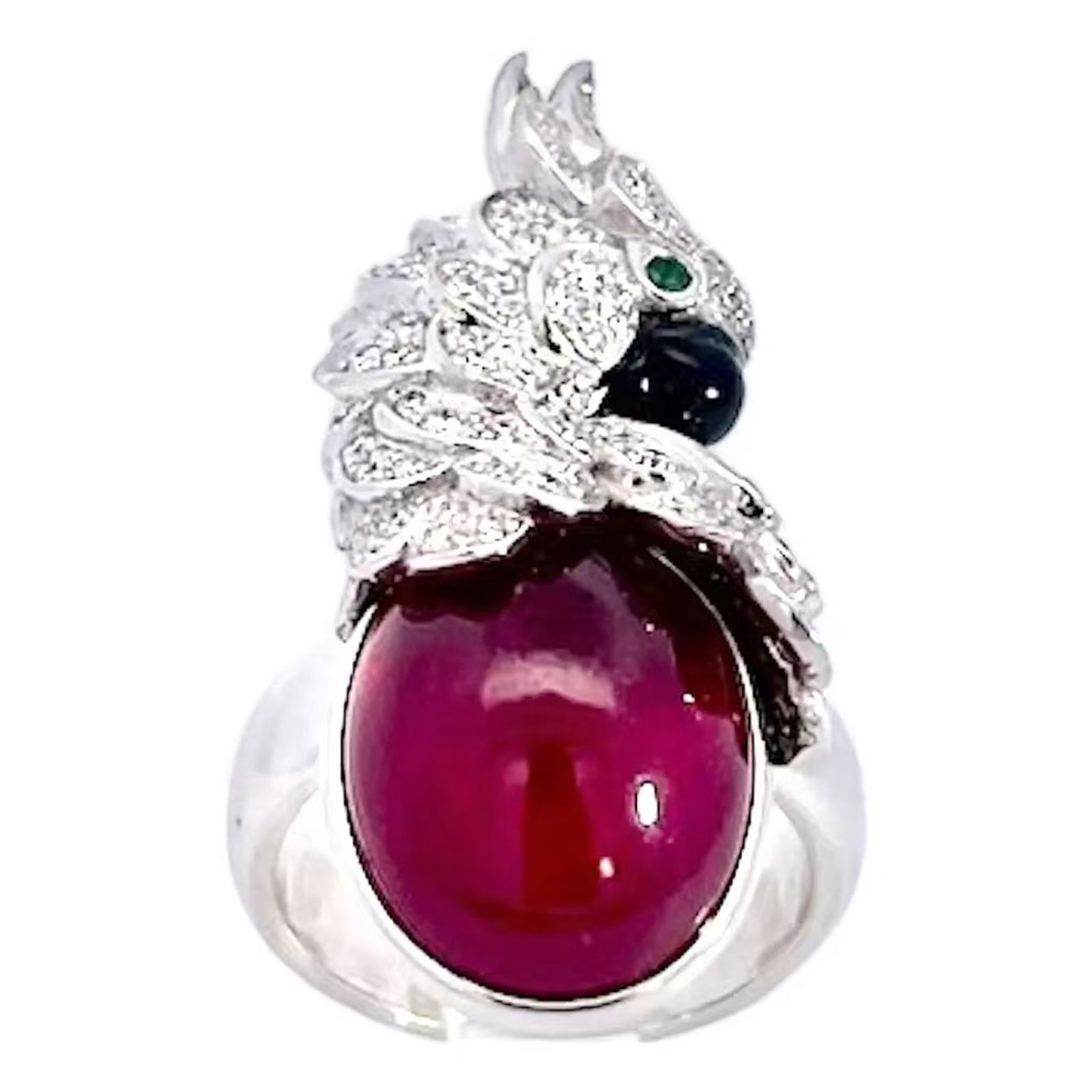 DRAGON MOTIF RUBY CABOCHON AND DIAMOND RING: A sculptural ring designed in the form of a stylized dragon wrapped around a large oval cabochon gemstone; the dragon's head and scales are intricately rendered in white metal and set with numerous sm