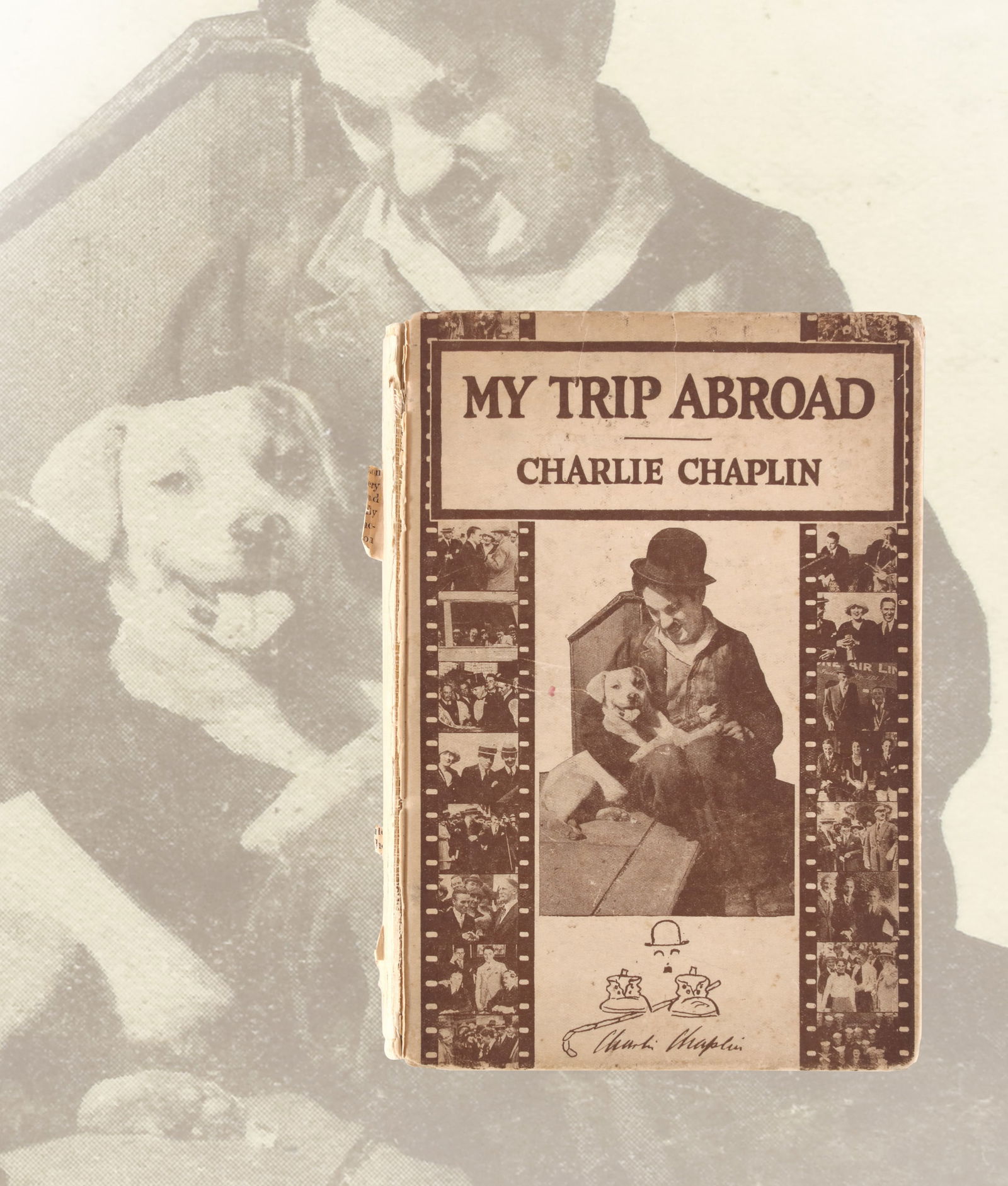 MY TRIP ABROAD (HARPER & BROTHERS, NEW YORK) BEARING SIGNATURE READING 'CHARLIE CHAPLIN': The book retains its publisher's pictorial binding featuring photographic panels from Chaplin's travels, with moderate edge wear and rubbing to the extremities. The interior pages remain generally