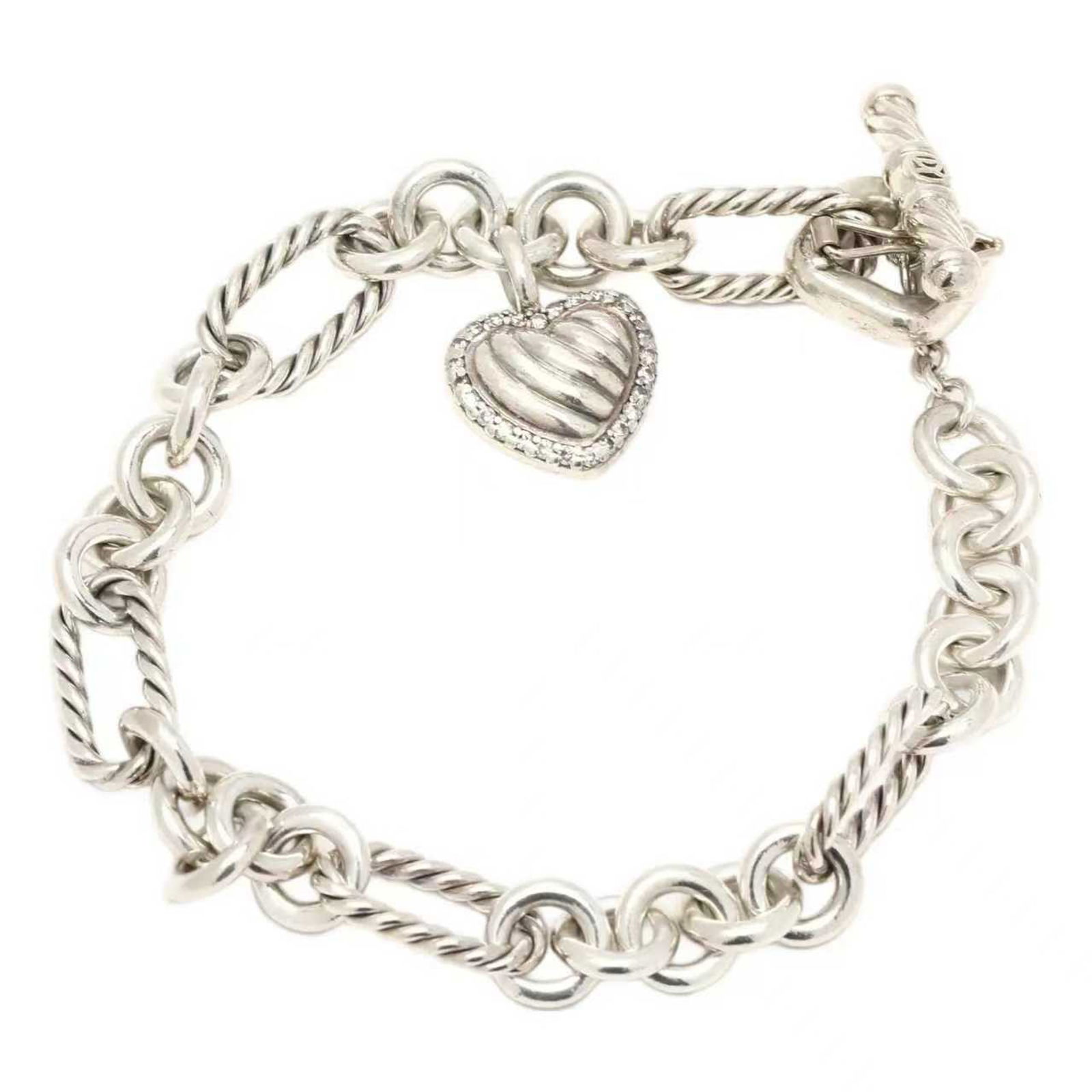 STERLING SILVER HEART CHARM LINK BRACELET: A sterling silver link bracelet composed of alternating twisted rope-style and smooth circular links; the bracelet is fitted with a toggle clasp for secure closure; suspended from the central link is