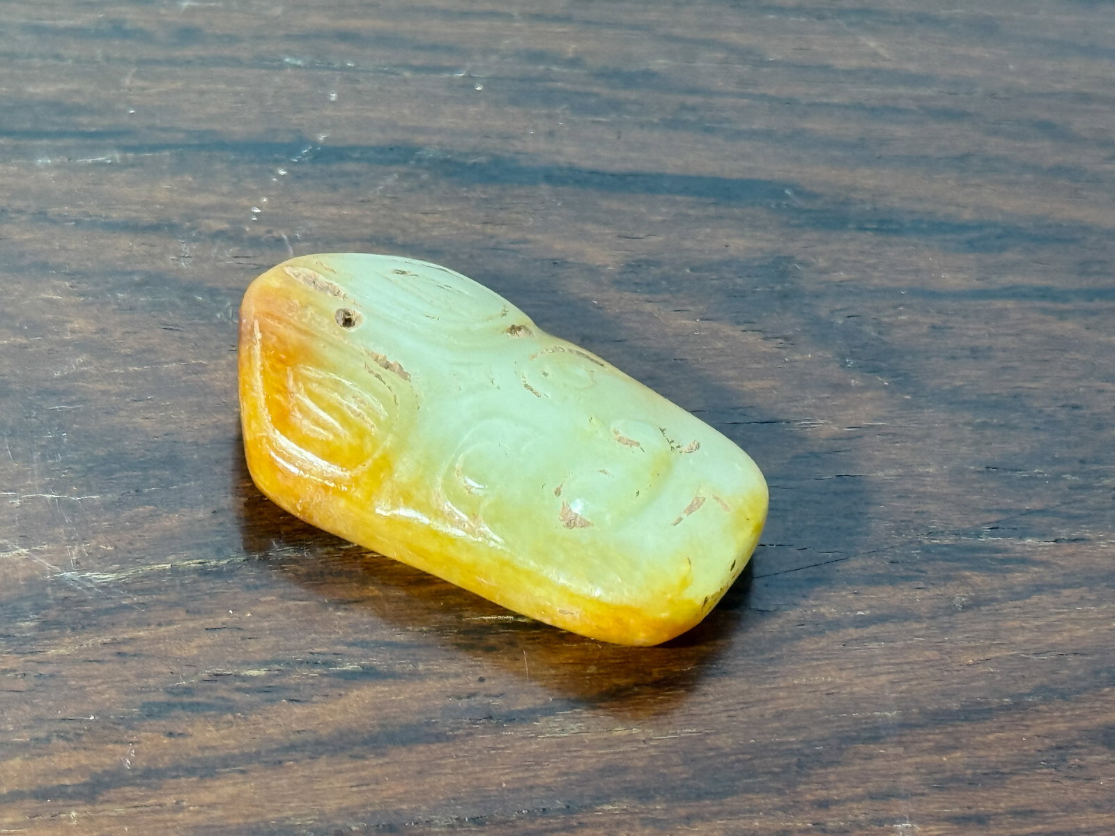 CHINESE JADE FLATTEN BEAD WITH ARCHAIC MASK MOTIF: Chinese jade flatten shaped bead pedant with archaic mask motif. Dimensions: Length: 1.5 in. (3.8 cm) Note: This item is in New York, where it can be shipped from.