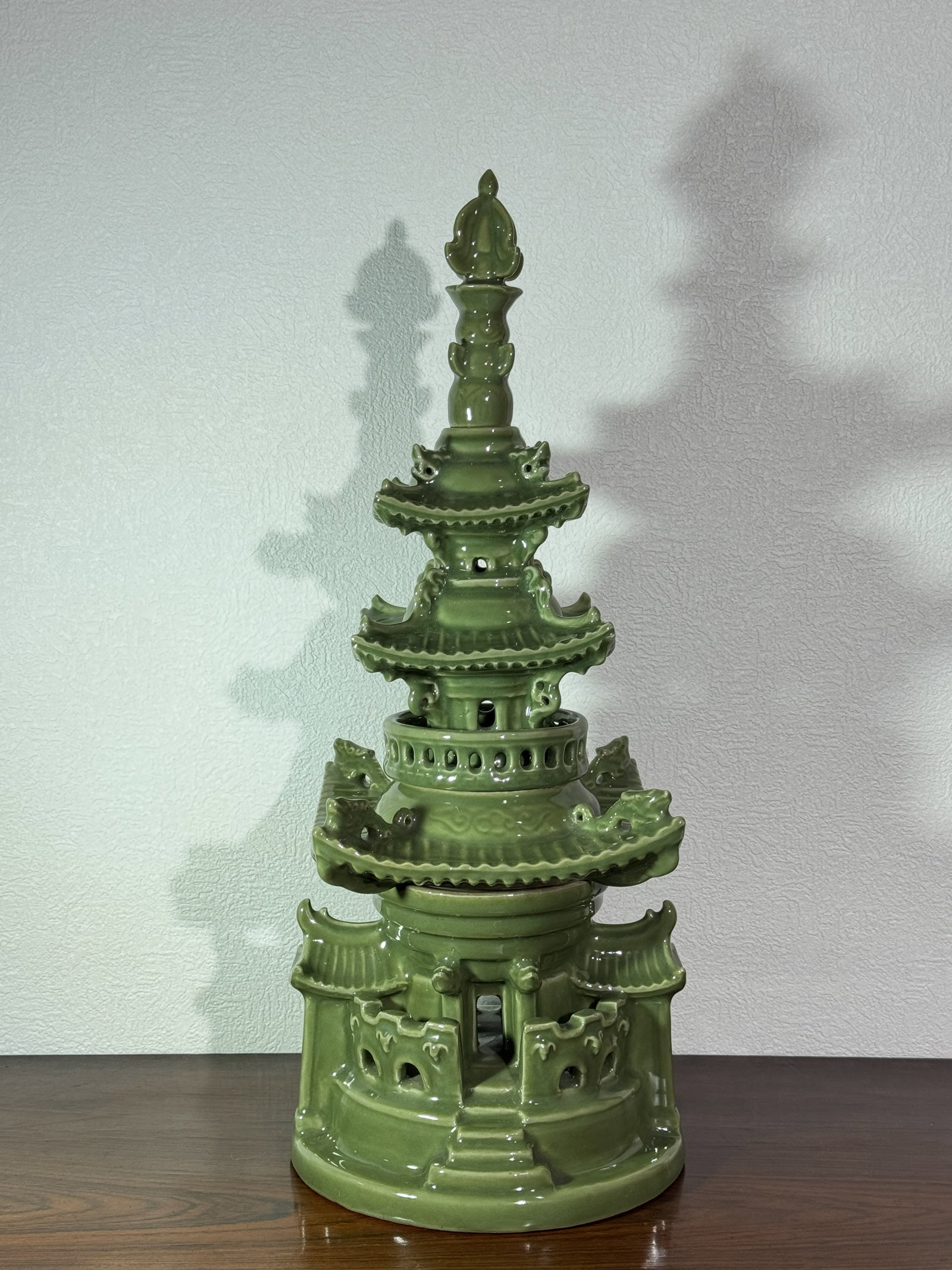 JAPANESE CELADON PORCELAIN PAGODA: Japanese celadon glazed porcelain model of a pagoda, fired in four section and stacked in layers. Signed with artist at bottom. Dimensions: Height: 20 in. (50.8 cm) Note: This item is in New York, whe