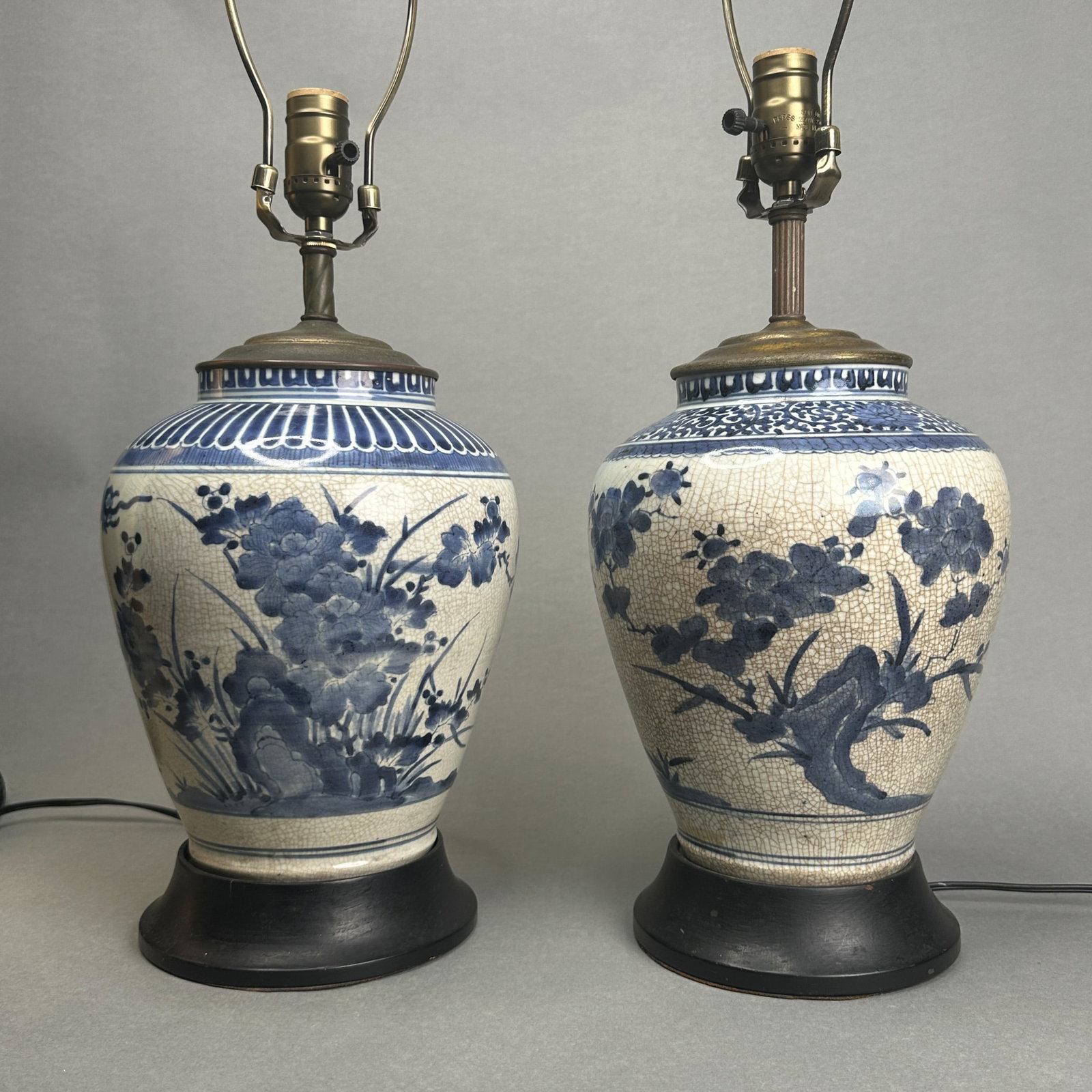 A PAIR OF JAPANESE EARLY ARITA PORCELAIN VASES: A pair of Japanese early Arita porcelain vases, 17th/18th century, both decorated with a floral scene. Dimensions: Vase height: 10 in. (25.4 cm); Overall height: 25 in. (63.5 cm).