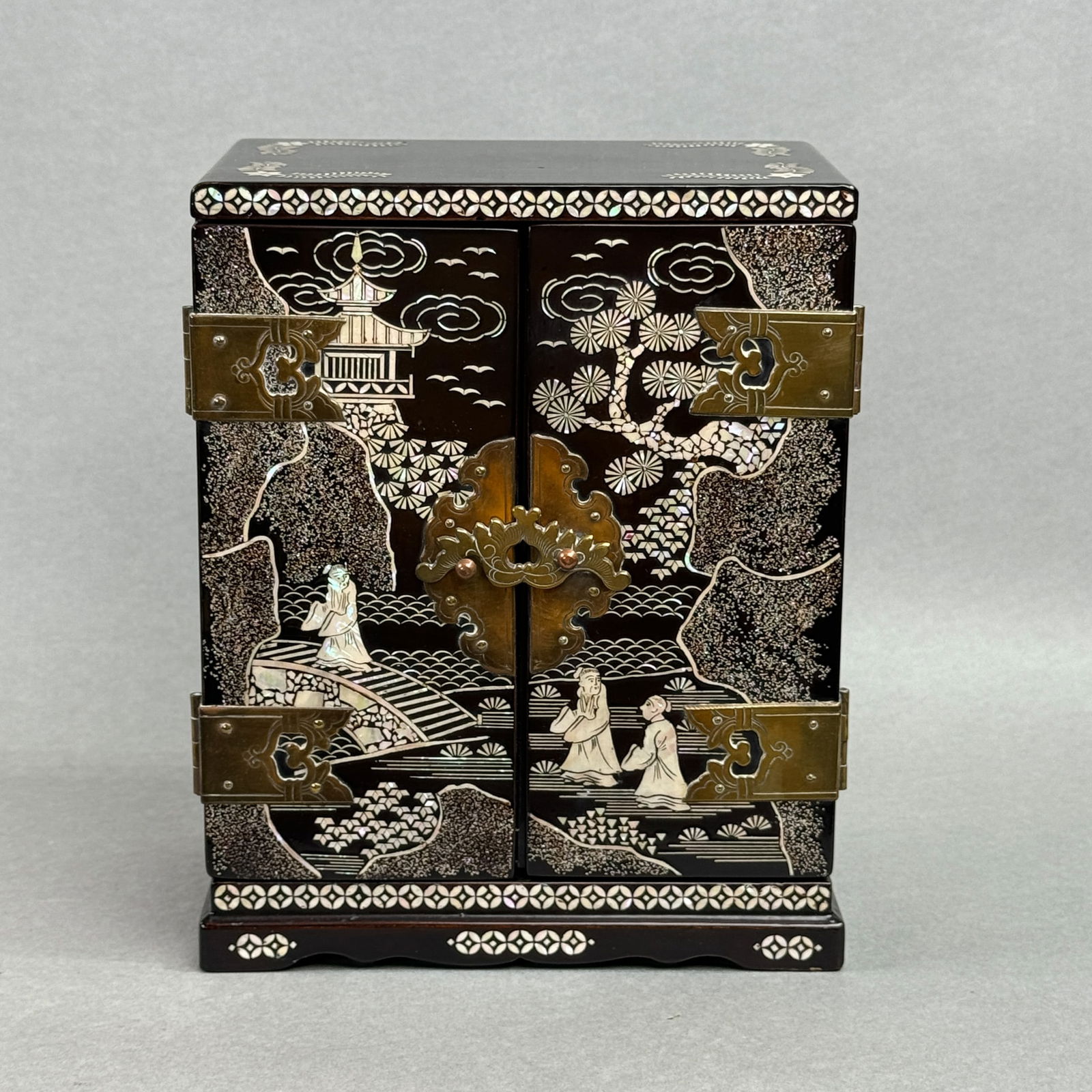 A JAPANESE LACQUER CASKET WITH MOTHER-OF-PEARL INLAYS: A Japanese black lacquer casket with mother-of-pearl inlays, Meiji period, depicting a scholar scene, with brass fittings, crack in the lacquer at the rear side edge as a sign of age. Dimensions: 8 x