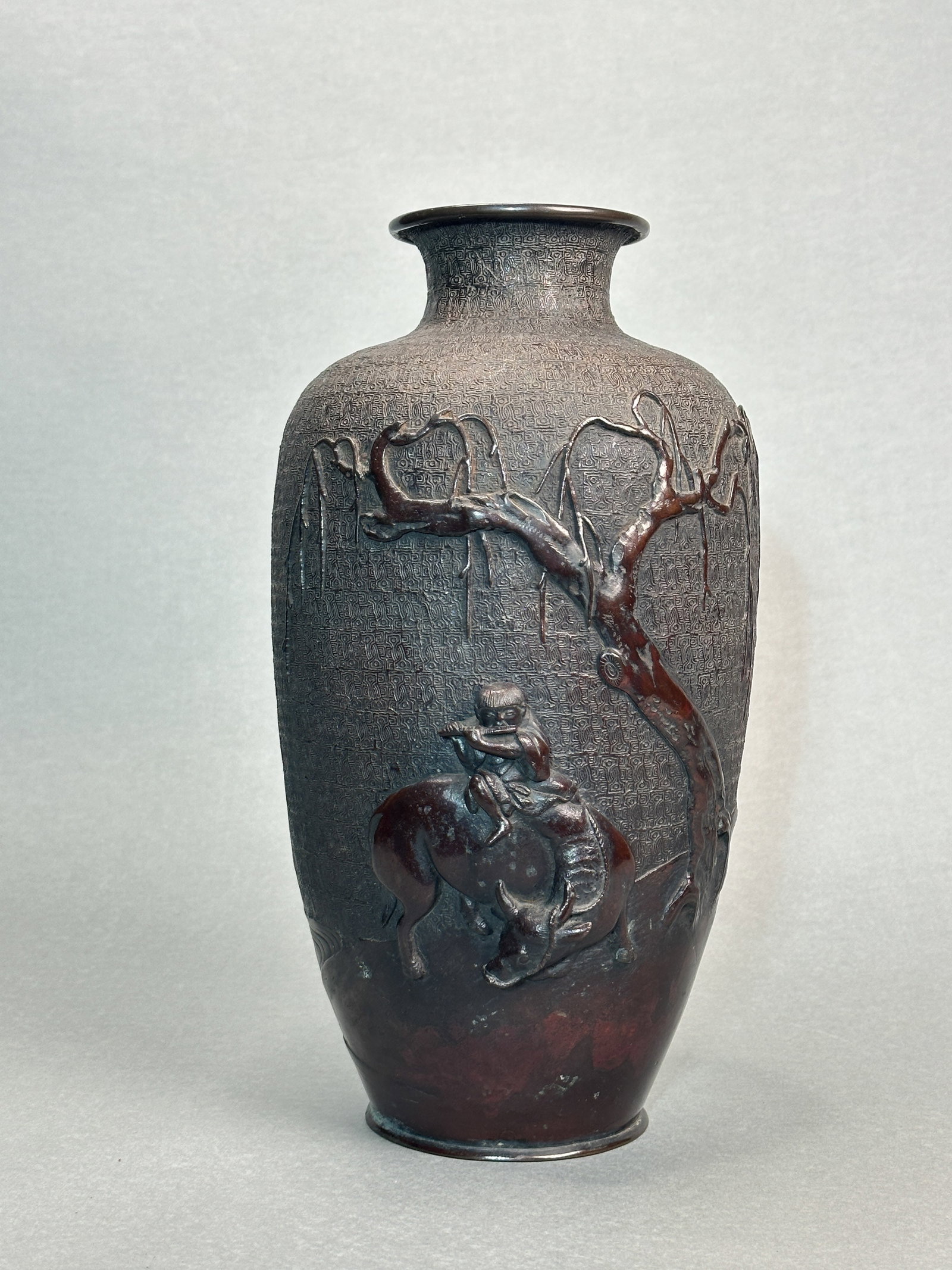 A JAPANESE BRONZE VASE WITH BOY RIDING OX: A Japanese bronze vase with a boy riding an ox, Meiji period, unsigned. Dimensions: Height: 12.5 in. (31.8 cm).