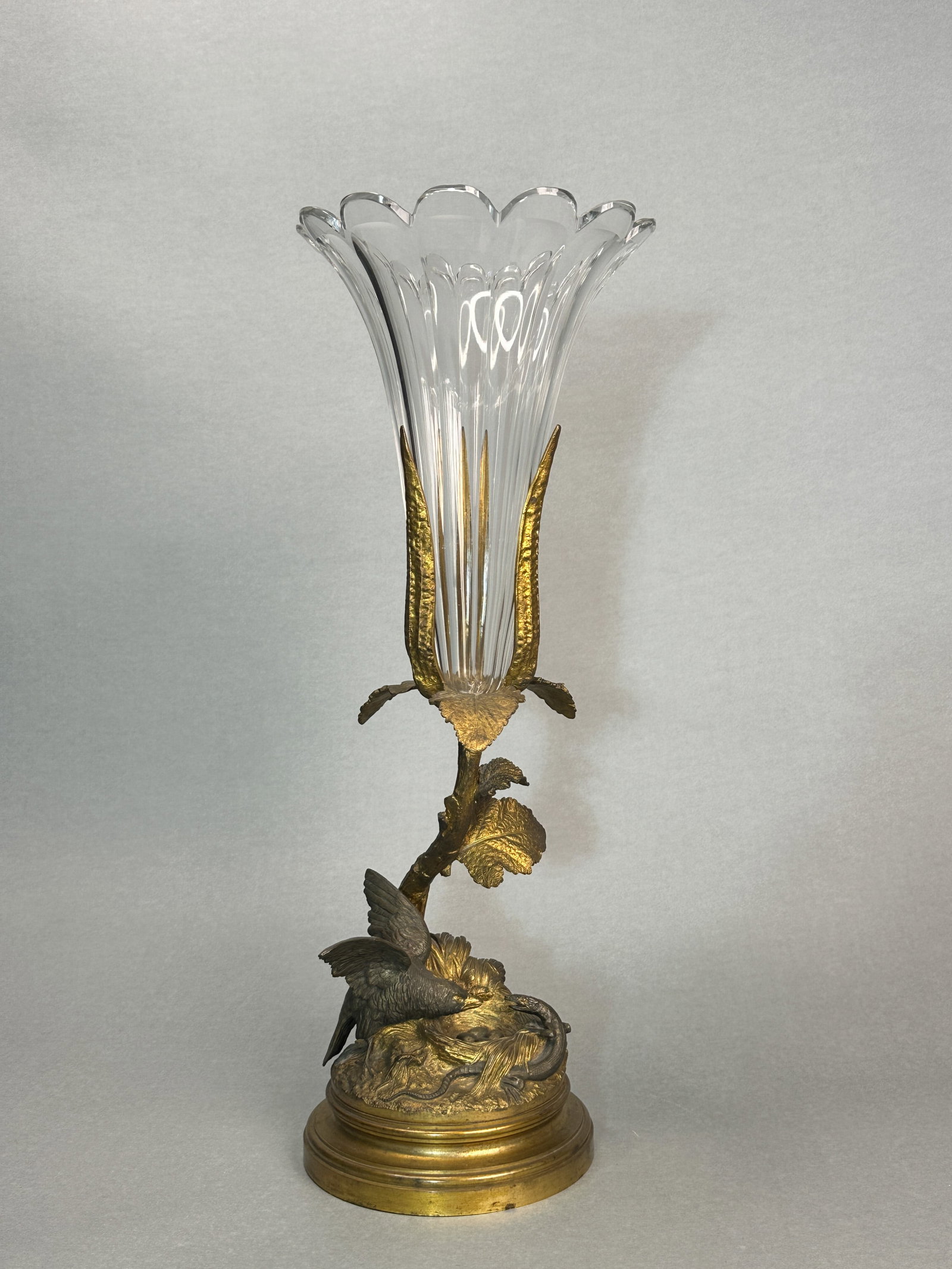A CONTINENTAL GILT BRONZE AND CUT GLASS VASE: A Continental gilt bronze and cut crystal vase, 19th century, decorated with a hawk fighting a snake scene. Dimensions: Height: 19.25 in. (48.9 cm).