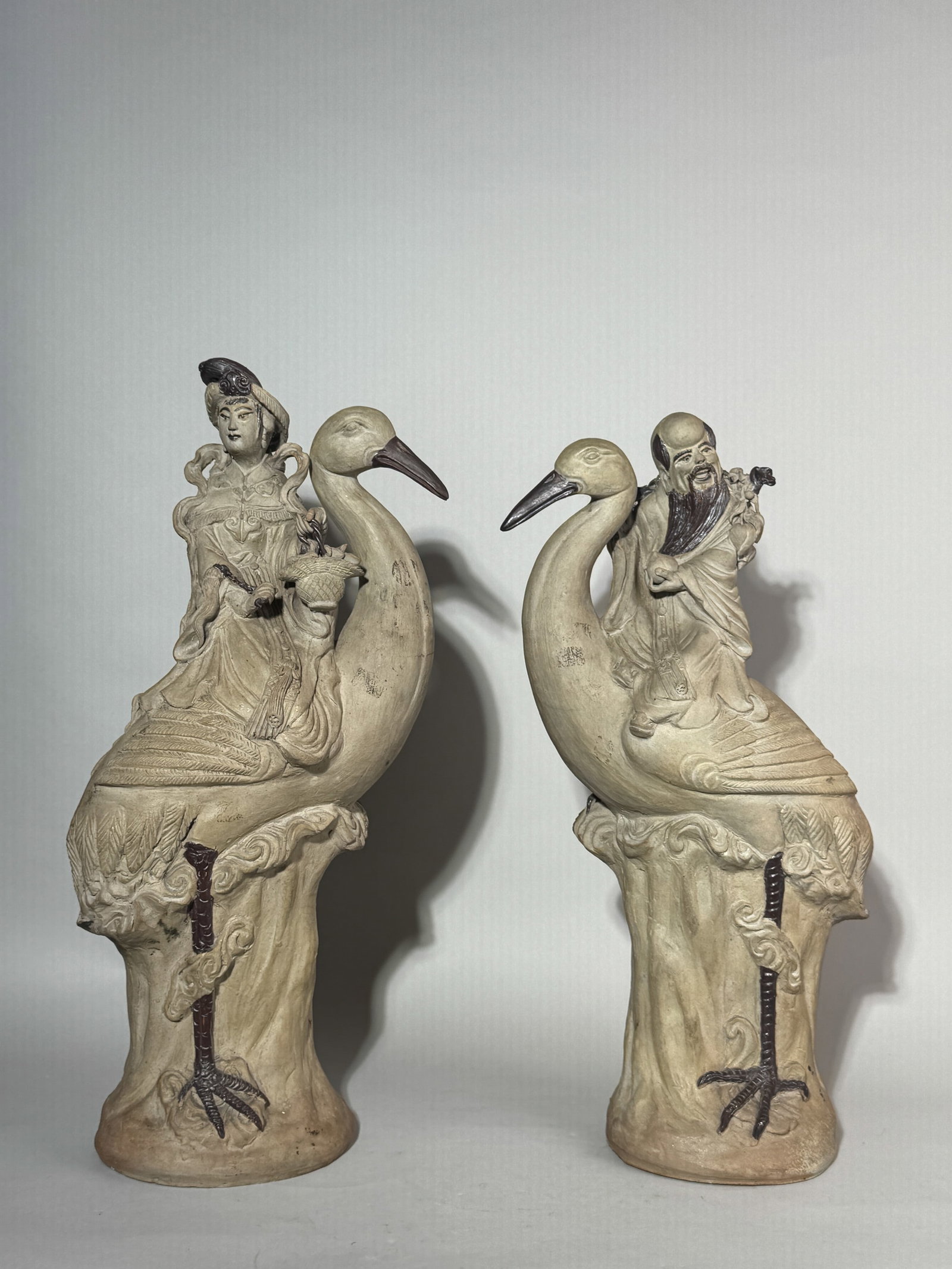 A PAIR OF CHINESE BISQUE PORCELAIN IMMORTALS RIDING CRANES: A pair of Chinese bisque porcelain immortals riding cranes. Dimensions: Height: 20 in. (50.8 cm) each. Note: This item is in New York, where it can be shipped from.