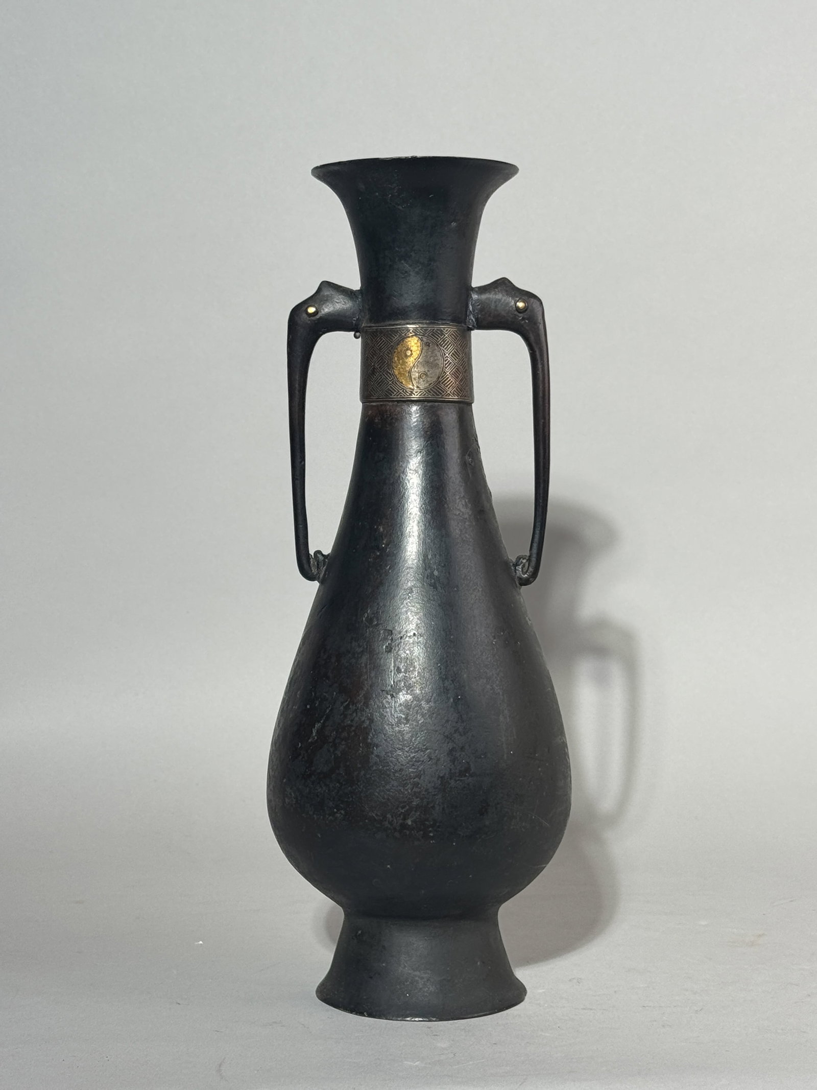 A CHINESE BRONZE VASE WITH GOLD AND SILVER INLAY: A Chinese bronze vase with gold and silver inlay of a Daoist yin-yang concept, 17th century. One side of the body has a dent as seen in the photo. Dimensions: Height: 11.75 in. (29.8 cm). Note: This i