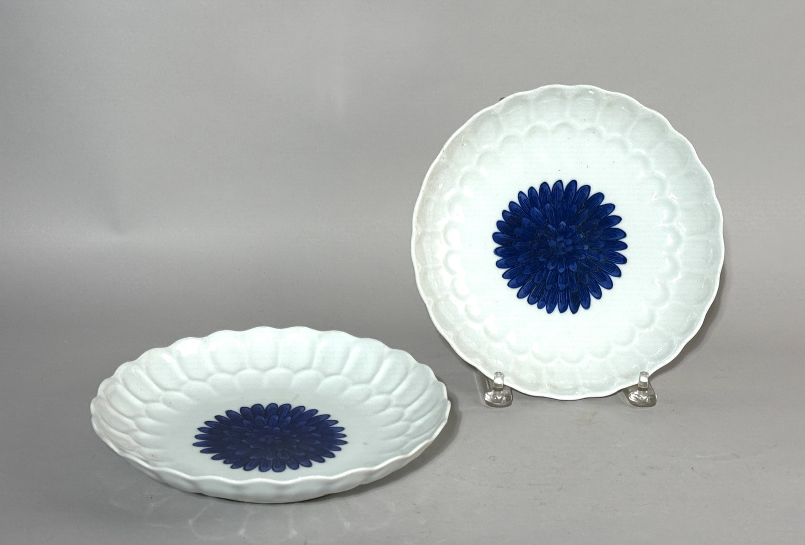A PAIR OF JAPANESE BLUE AND WHITE PORCELAIN CHRYSANTHEMUM DISHES: A pair of Japanese blue and white porcelain chrysanthemum dishes, with a maker's impressed mark. Dimensions: Diameter: 9 in. (22.9 cm) each. Note: This item is in New York, where it can be shipped fro