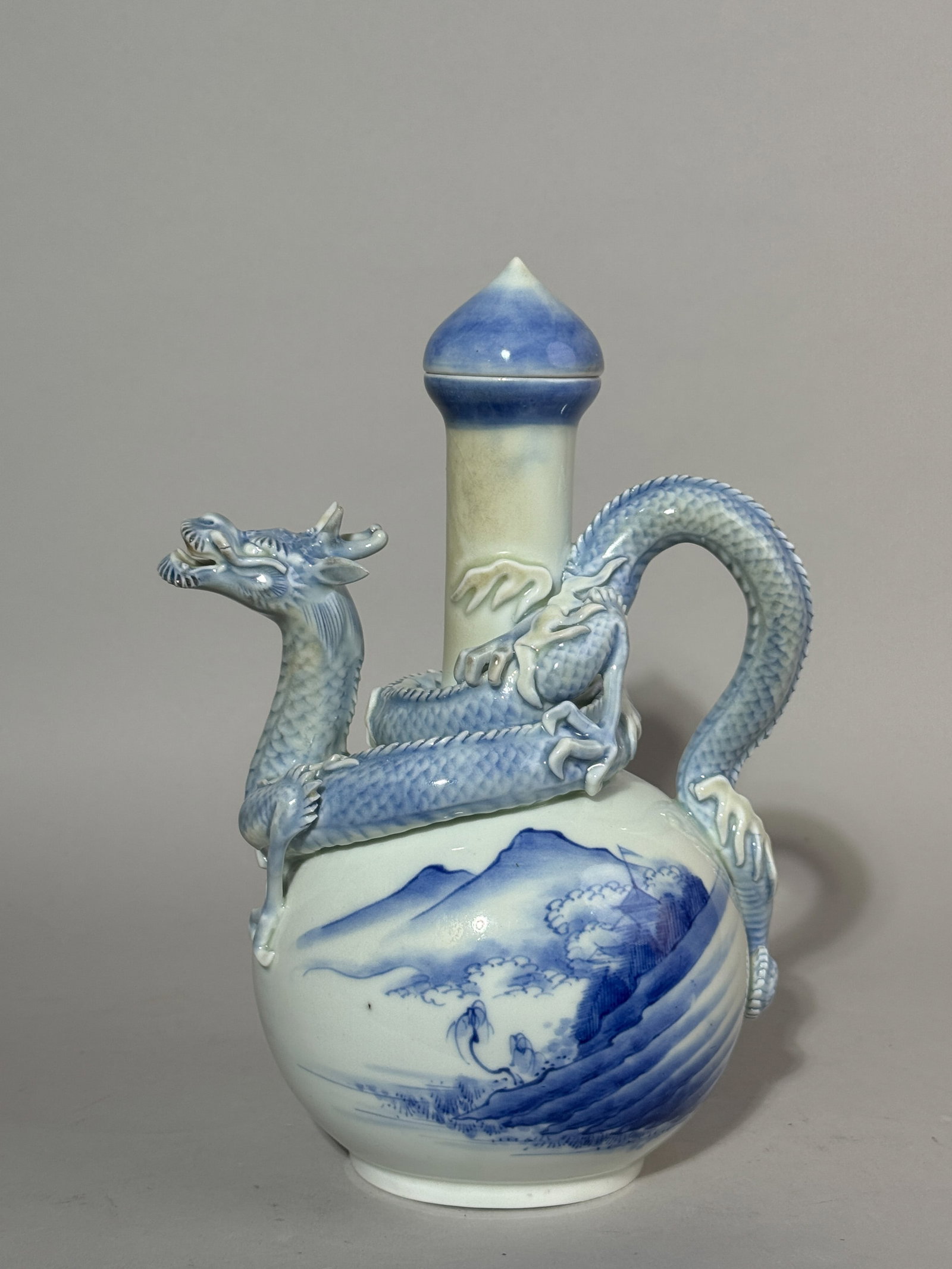 AN ANTIQUE HIRADO PORCELAIN DRAGON EWER: An antique Japanese Hirado porcelain ewer with a dragon spout. Cover has an edge chip, slight yellow kiln ash on the neck of the ewer. Dimensions: Height: 10 in. (25.4 cm). Note: This item is in New