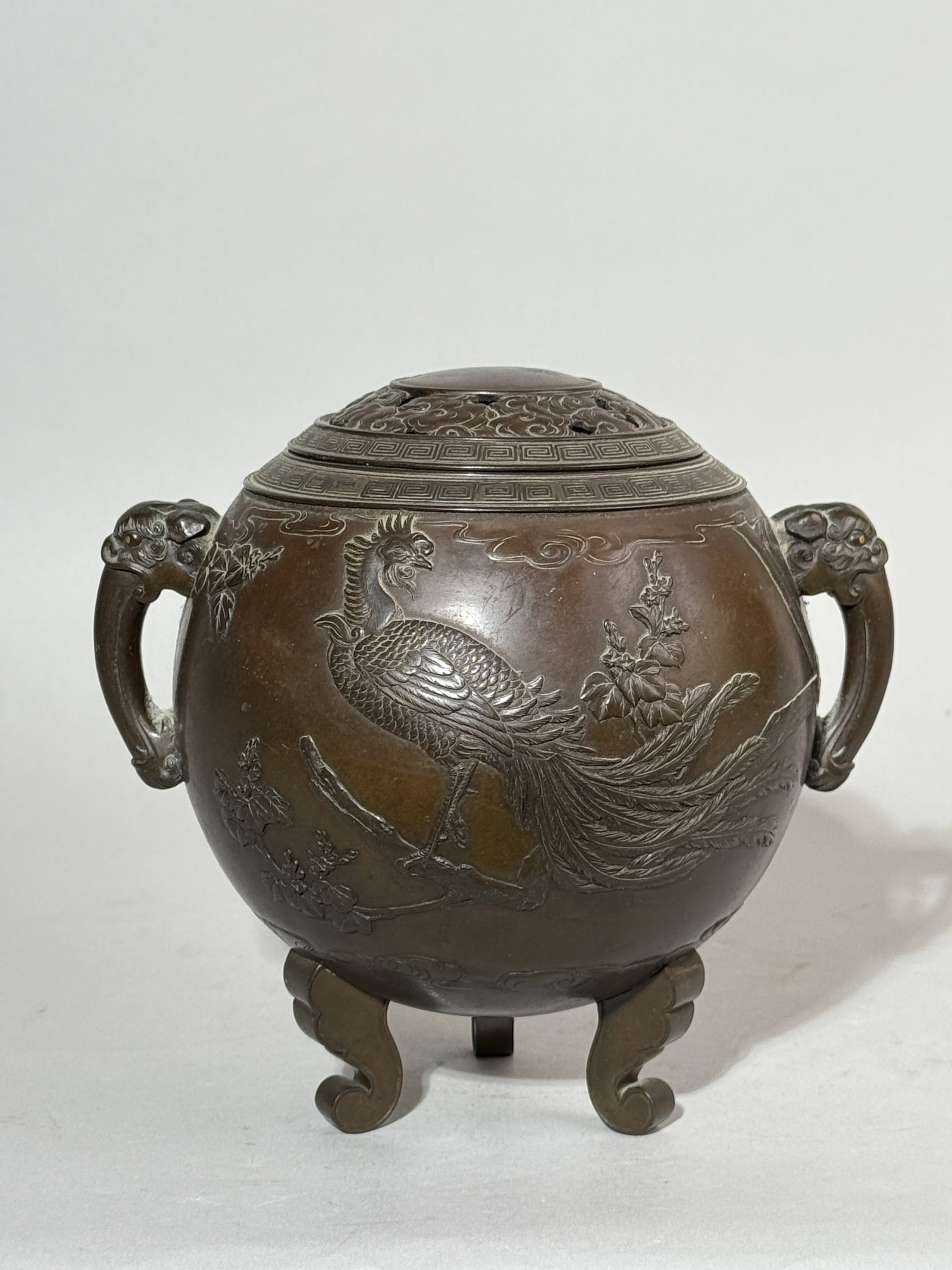 JAPANESE SIGNED MEIJI BRONZE CENSER WITH GOLD INLAY EYE: A finely detailed Japanese Meiji period bronze censer with a phoenix design, signed, with gold inlaid eyes and a silver liner interior. Missing the finial on top of the cover. Dimensions: Height: 6.5