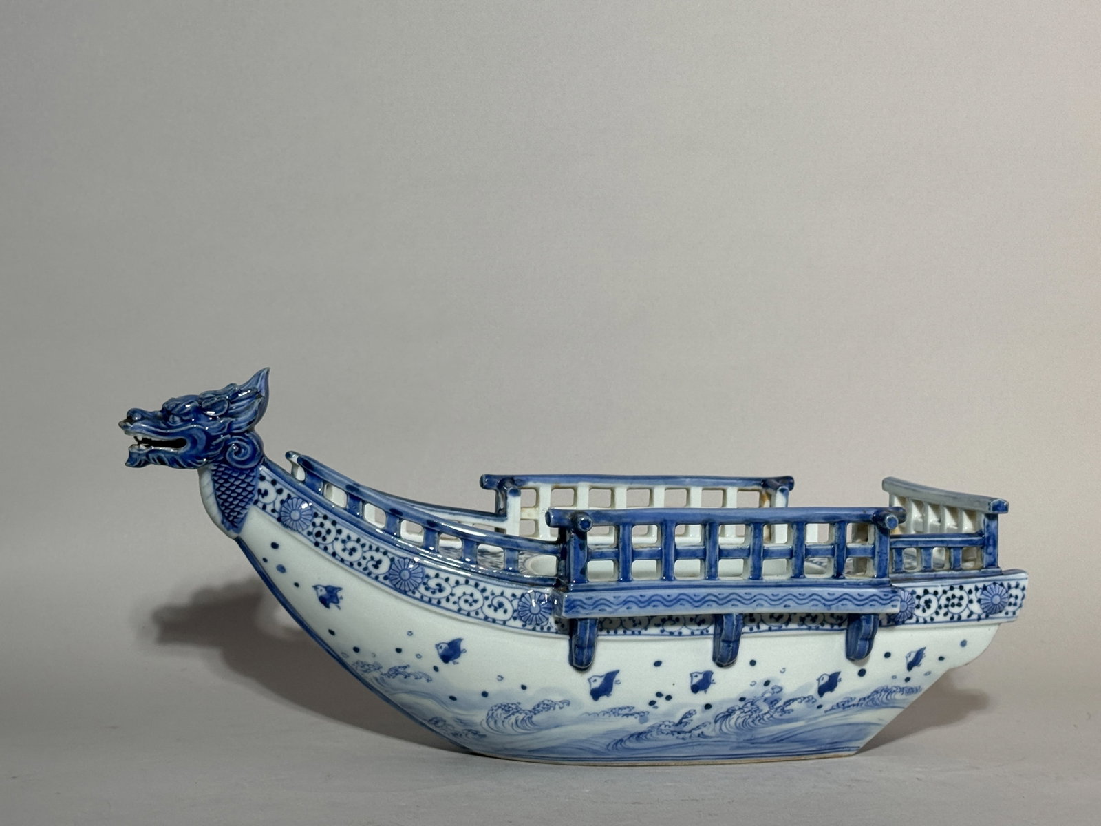 JAPANESE HIRADO PORCELAIN DRAGON BOAT: A Japanese Hirado porcelain dragon boat with blue and white bird and wave decoration, Meiji period. Dimensions: Length: 16 in. (40.6 cm); Height: 6.75 in. (17.1 cm). Note: This item is in New York,