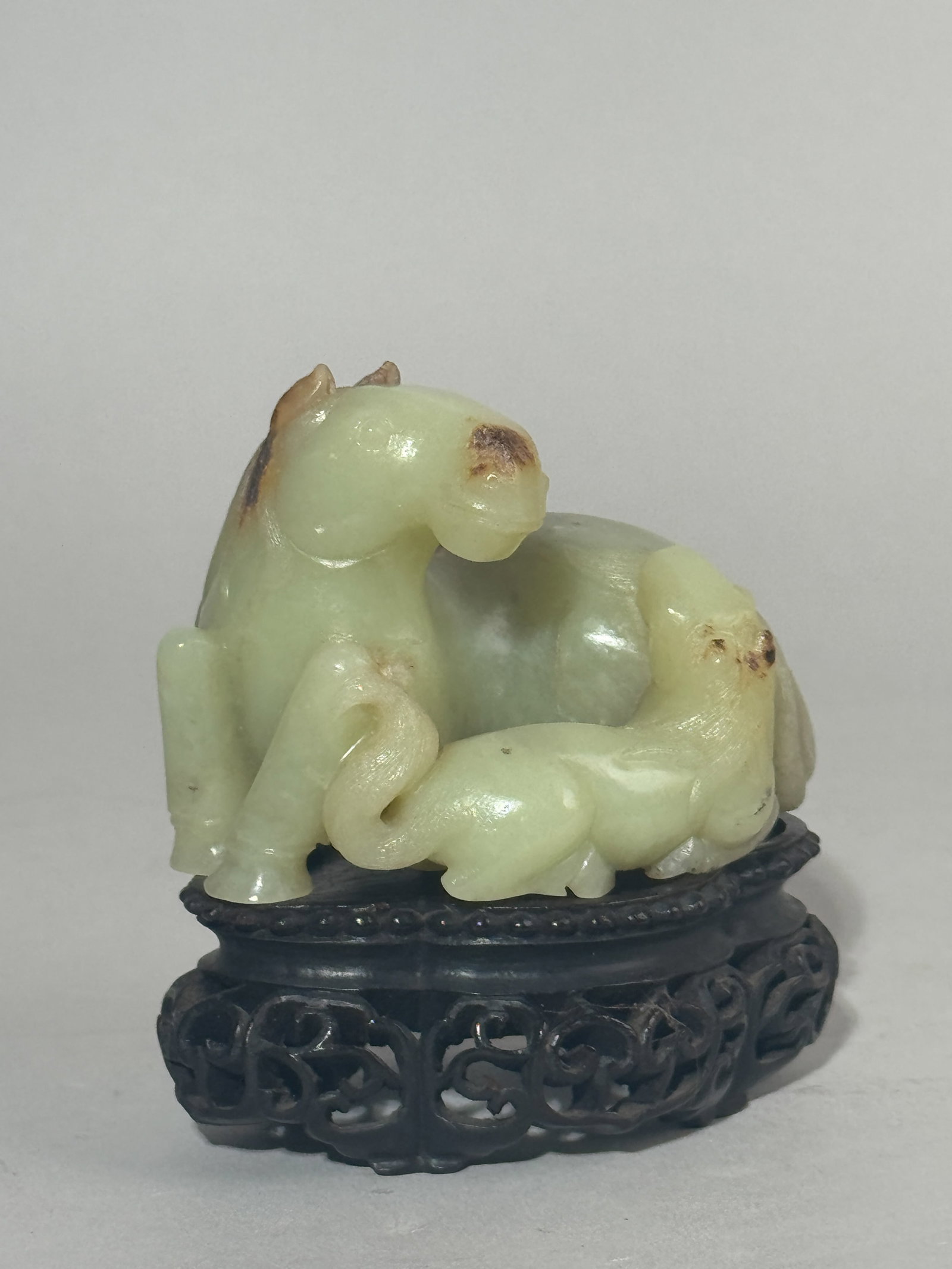 CHINESE YELLOW JADE CARVING OF HORSE FAMILY: A Chinese yellow jade carving of a horse family, on a hardwood base. Dimensions: Jade width: 3.5 in. (8.9 cm). Note: This item is in New York, where it can be shipped from.