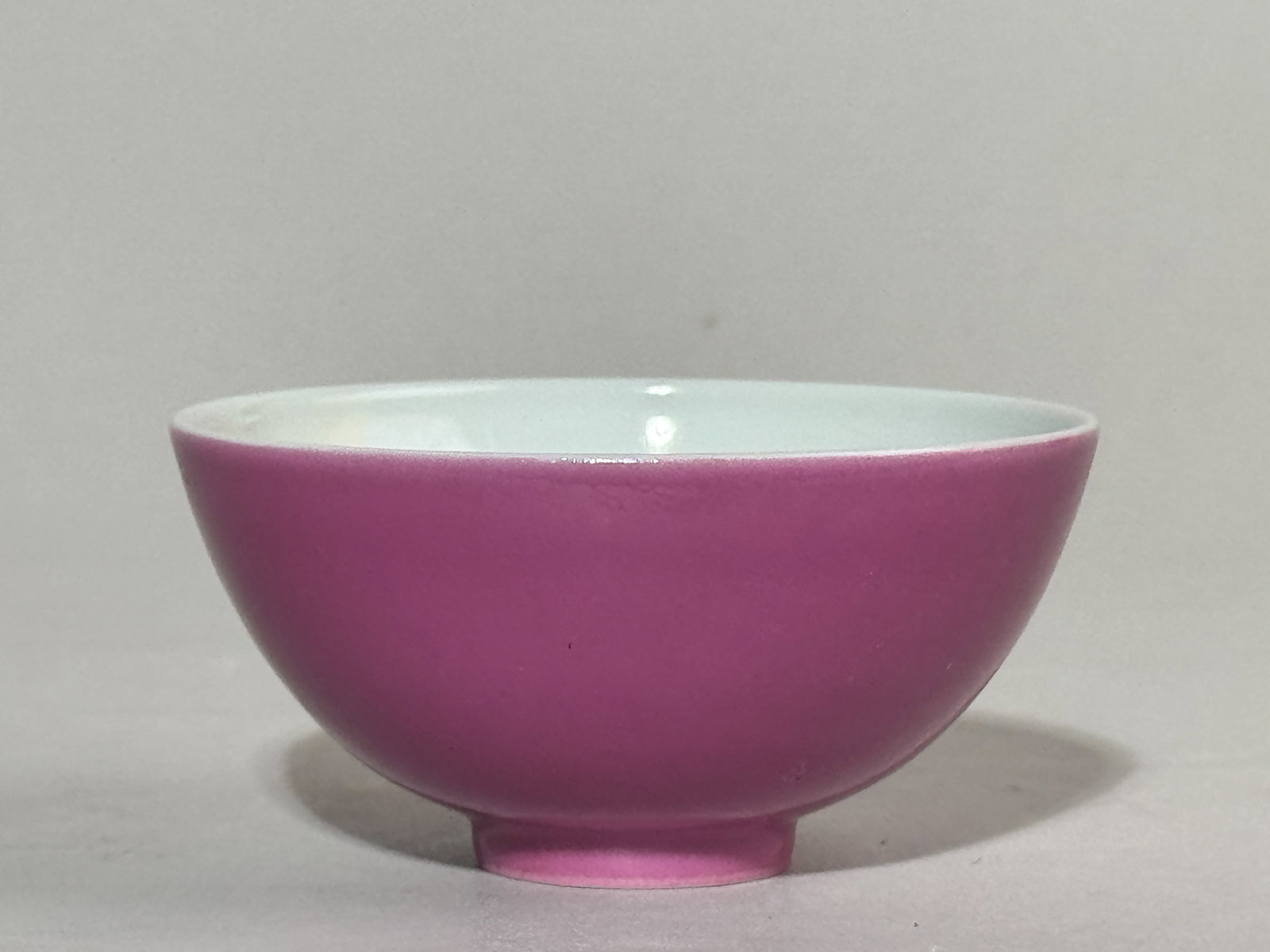 CHINESE RUBY ENAMELED PORCELAIN TEA BOWL: A Chinese miniature tea bowl with ruby pink enamel and an underglaze blue six-character mark. Dimensions: Diameter: 3.3 in. (8.4 cm). Note: This item is in New York, where it can be shipped from.