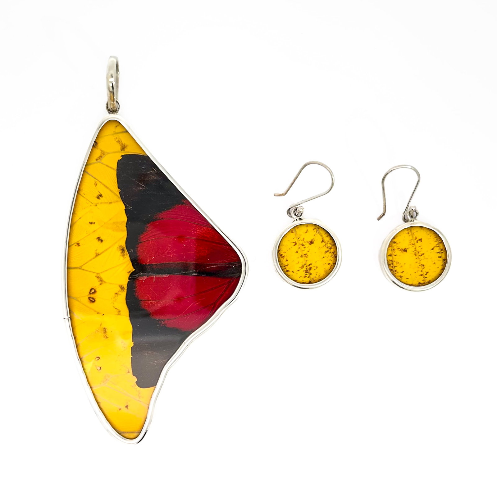 PENDANT AND EARRINGS SET: (lot of 3) Pendant and earrings set featuring real Peruvian Amazon habitat Phoebis butterfly wings in silver settings. Pendant: 3.35"h x 1.97"w (8.5 x 5 cm), earrings: 0.51"d (1.3 cm) (x2)