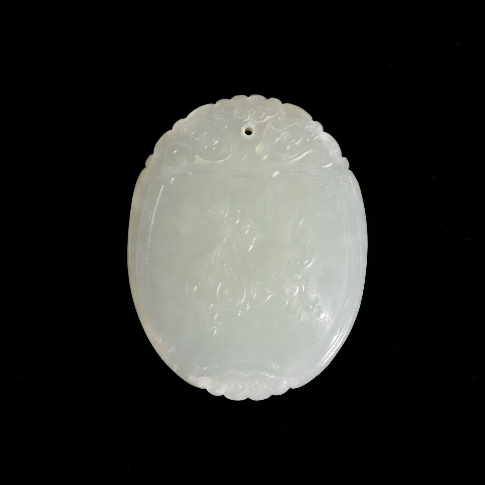 A CHINESE CARVED WHITE JADE PLAQUE: A Chinese carved white jade plaque. 2.17"h x 1.69"w x 0.24"l (5.5 x 4.3 x 0.6 cm)