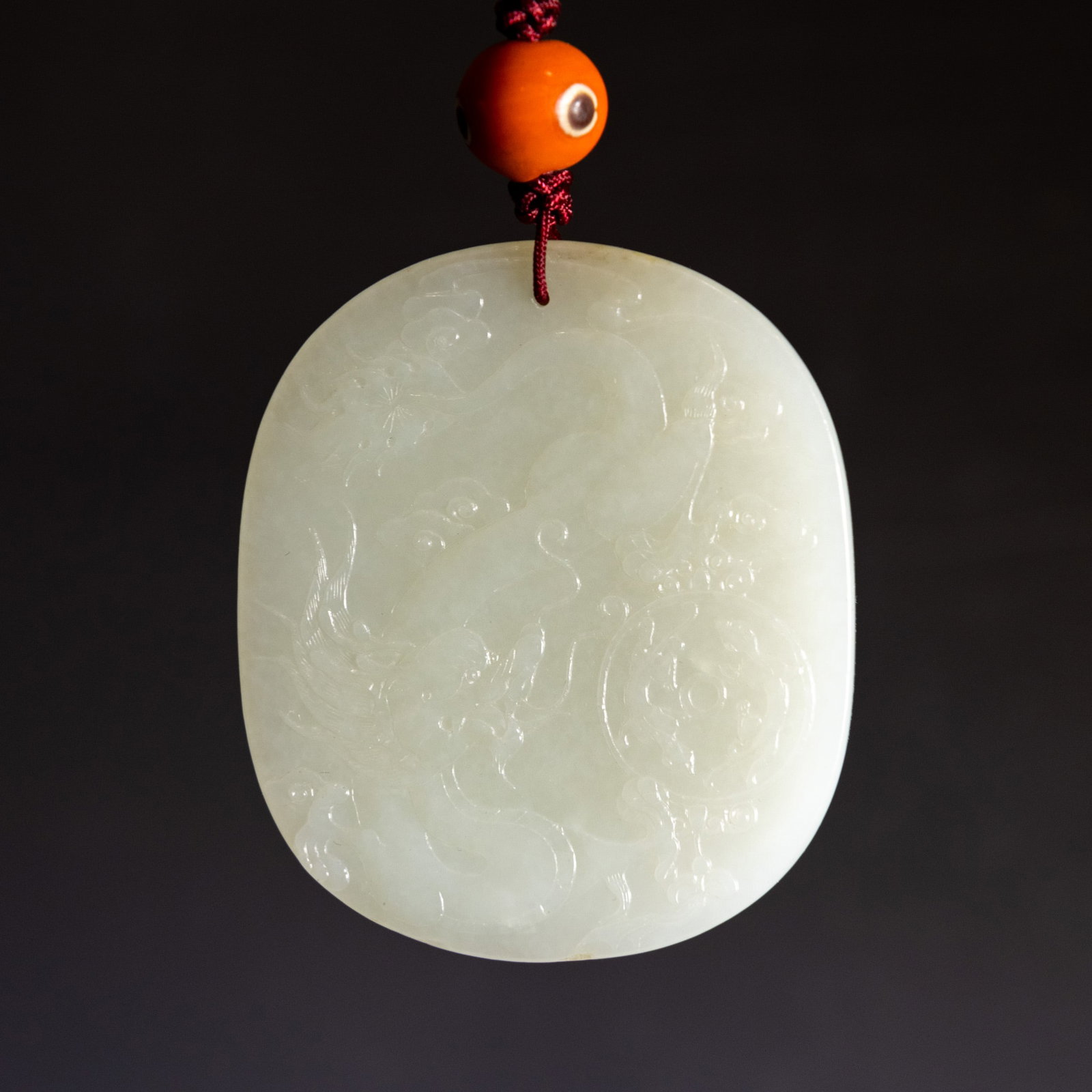 A CHINESE CARVED WHITE JADE PLAQUE PENDANT: A Chinese carved white jade plaque pendant. 2.76"h x 2.36"w x 0.28"l (7 x 6 x 0.7 cm)