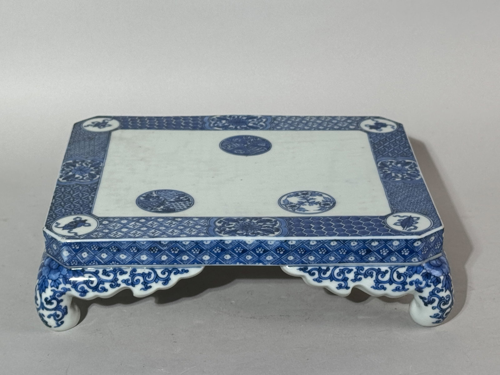 JAPANESE SETO BLUE AND WHITE PORCELAIN STAND: A Japanese Seto kiln blue and white porcelain stand, Meiji period. Dimensions: 11 x 9.25 in. (27.9 x 23.5 cm); Height: 3 in. (7.6 cm). Note: This item is in New York, where it can be shipped from.