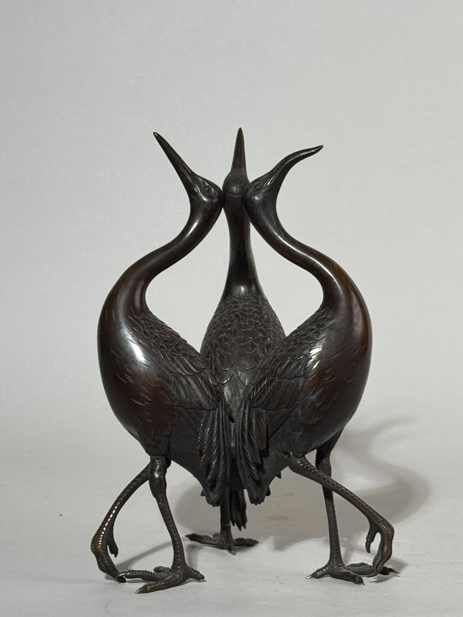 JAPANESE MEIJI BRONZE CRANE GROUP: A Japanese Meiji period bronze crane group, very detailed casting, unsigned. One of the legs is reglued. Dimensions: Height: 7.5 in. (19.1 cm). Note: This item is in New York, where it can be shipped 