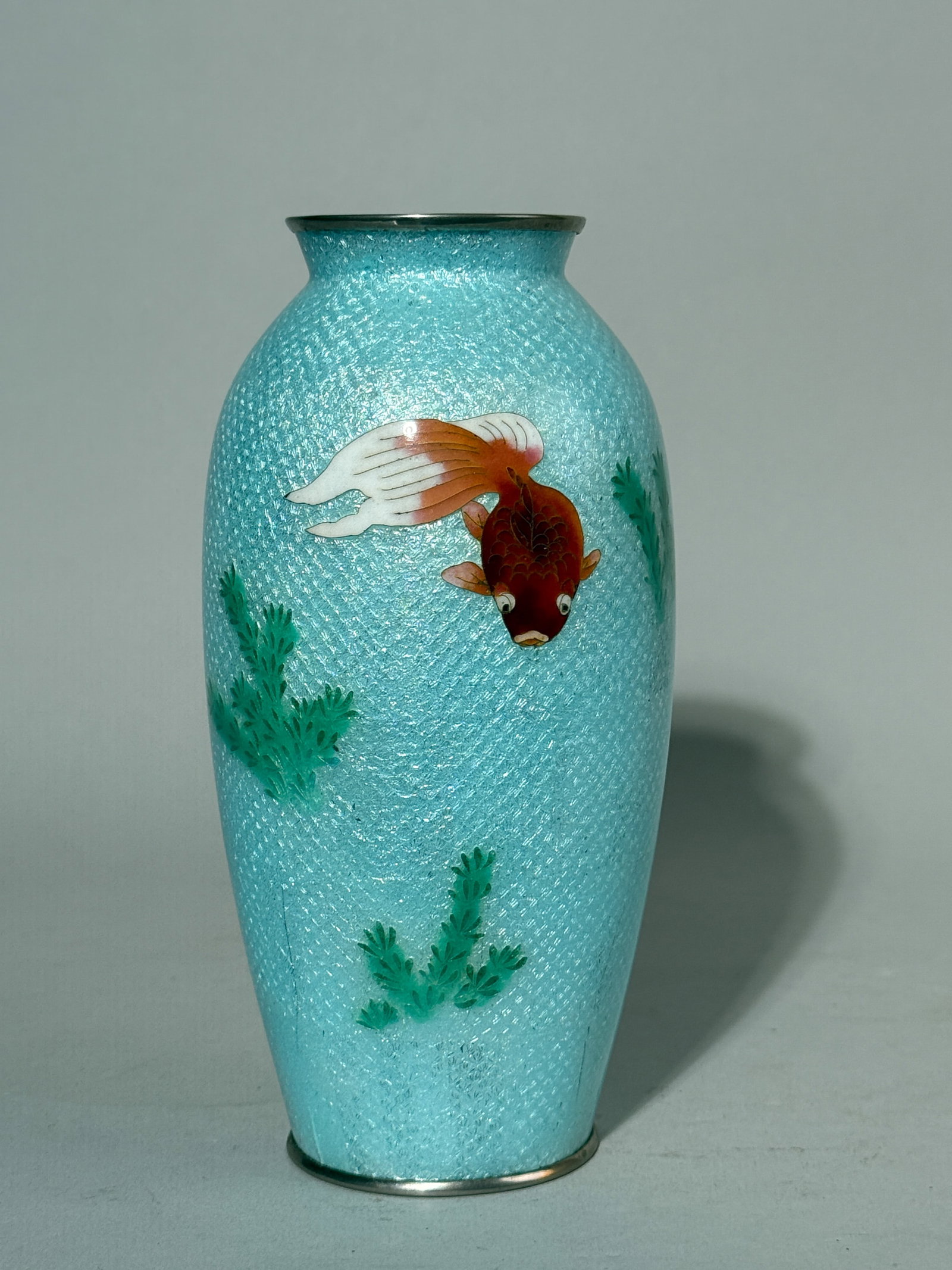 JAPANESE GINBARI CLOISONNE BY ANDO: A Japanese ginbari cloisonne vase by Ando Jubei, with a goldfish design and a mark at the bottom. Small stress line in the clear enamel. Dimensions: Height: 7.25 in. (18.4 cm). Note: This item is in N