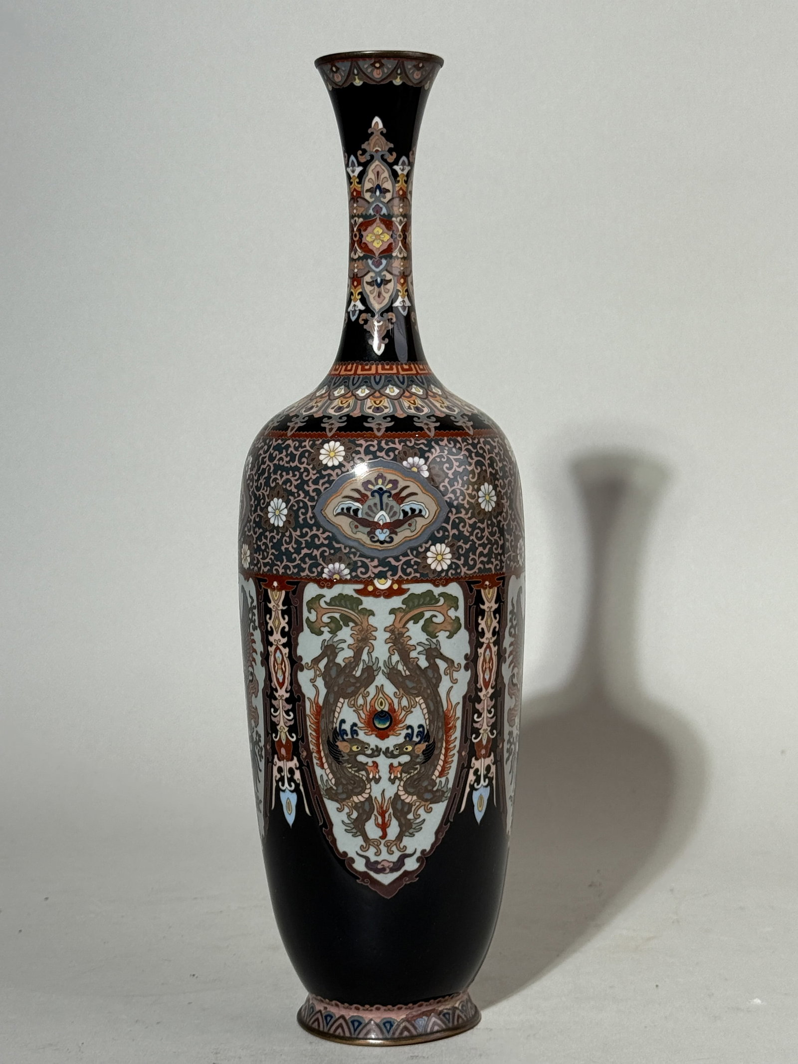JAPANESE MEIJI CLOISONNE VASE WITH FANCY DRAGON PHOENIX DESIGN: A Japanese Meiji period cloisonne vase with a fancy stylized dragon and phoenix design. Enamel chips. Dimensions: Height: 12 in. (30.5 cm). Note: This item is in New York, where it can be shipped from