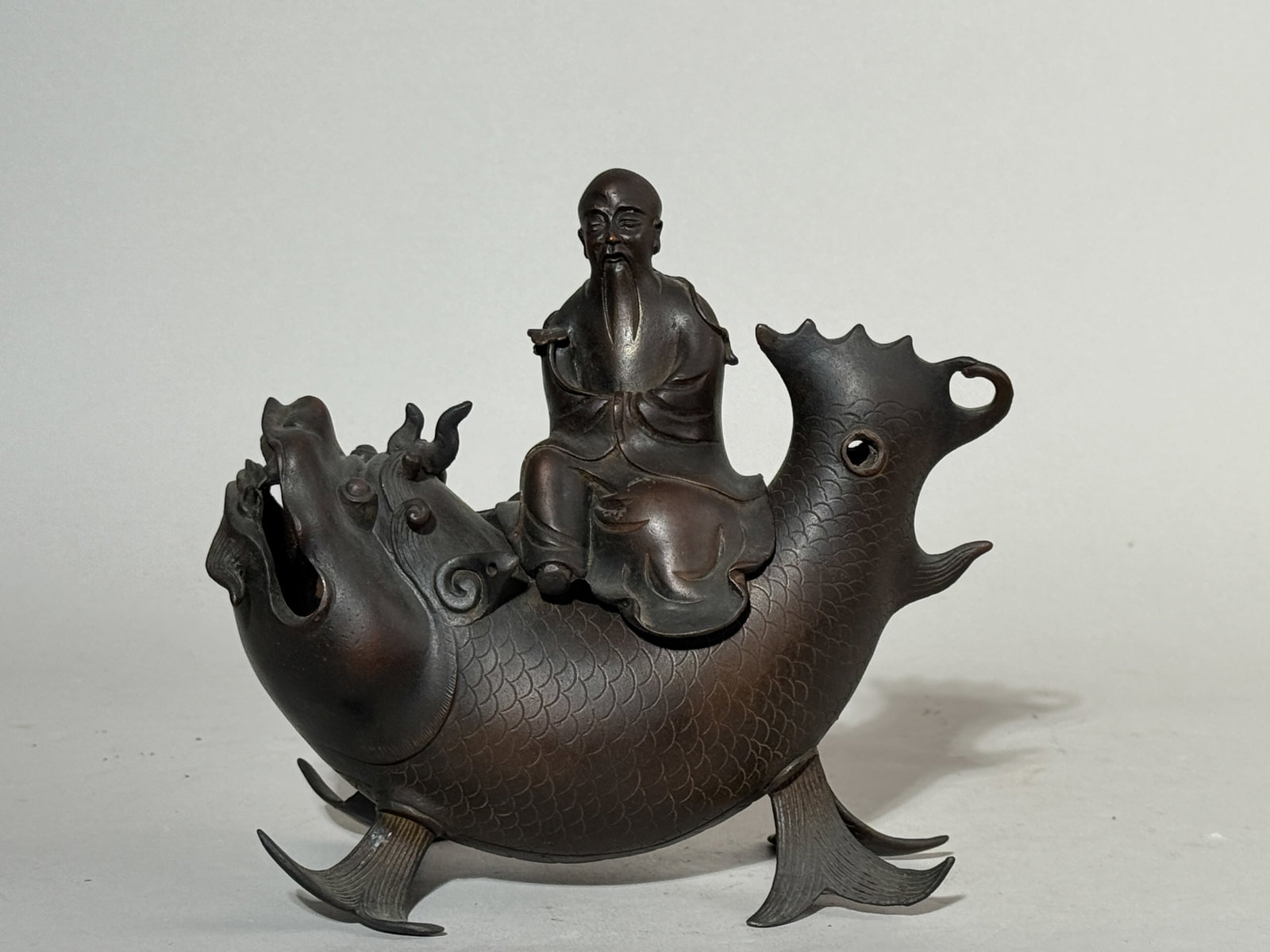 CHINESE BRONZE CENSER IMMORTAL ON DRAGONFISH: A Chinese Ming dynasty bronze censer of a scholar on a dragon fish. Dimensions: Width: 7 in. (17.8 cm). Note: This item is in New York, where it can be shipped from.