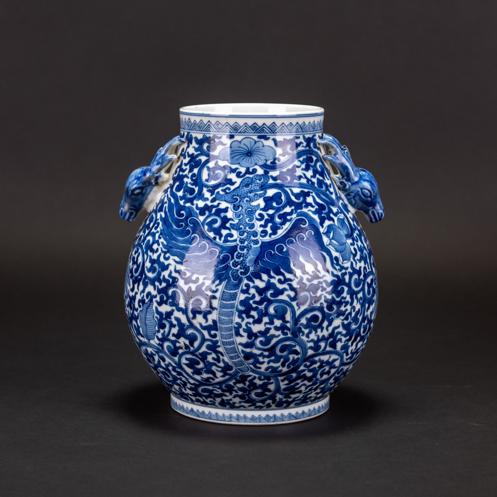 A CHINESE BLUE AND WHITE "LOTUS AND PHOENIX" PORCELAIN VASE: A Chinese blue and white porcelain vase with lotus and phoenix design, deer-shaped ears. 9.06"h x 7.87"d (23 x 20 cm)