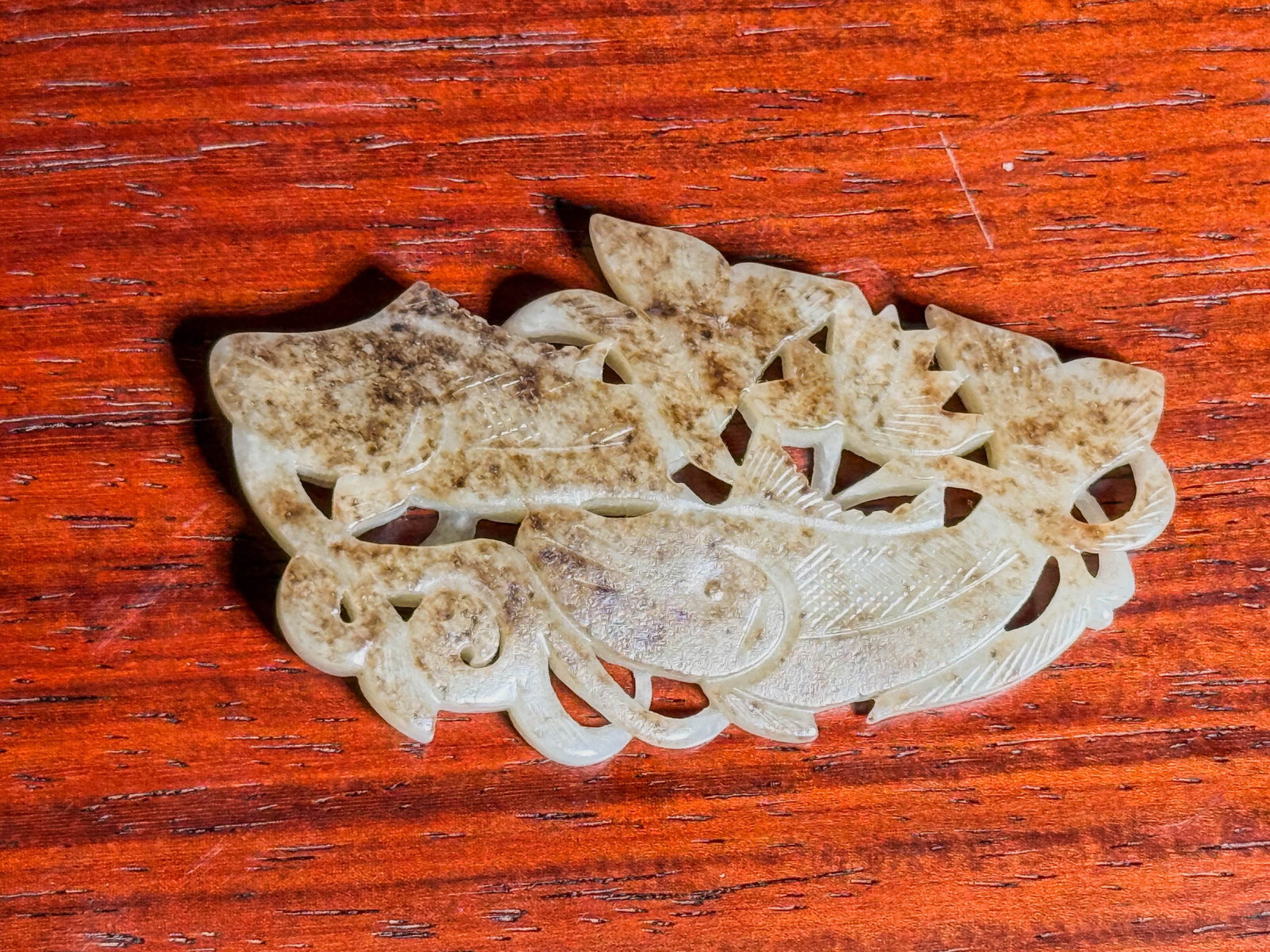 CHINESE JADE PENDANT WITH TWIN FISH: A Chinese jade pendant with a twin-fish design and spotted russet-brown skin. Dimensions: Length: 2.6 in. (6.6 cm). Note: This item is in New York, where it can be shipped from.