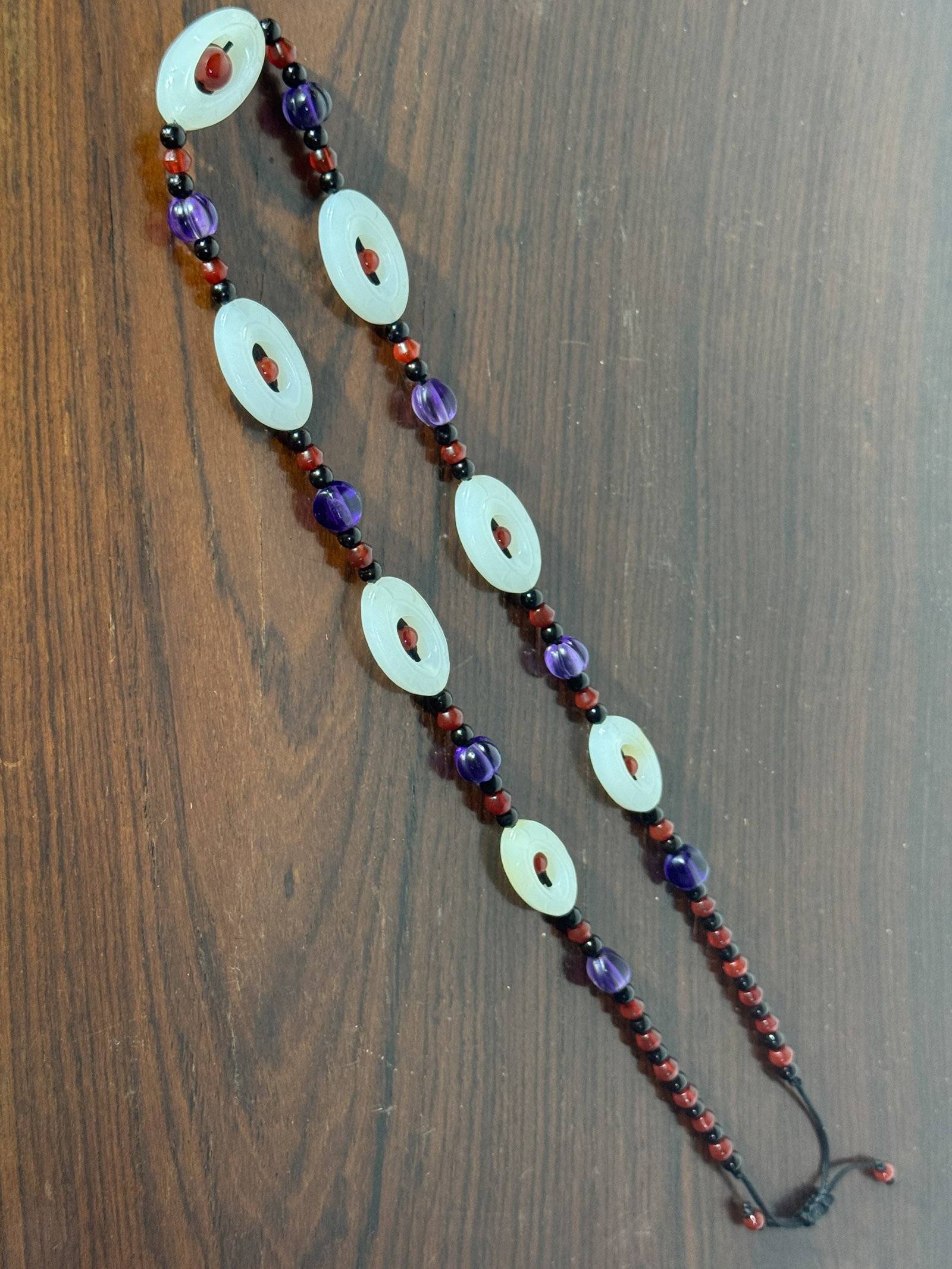 CHINESE WHITE JADE NECKLACE WITH AMETHYST AND AGATE: Chinese white jade oval-shaped ring necklace with amethyst and small agate beads. Dimensions: Circumference: 22 in. (55.9 cm). Note: This item is in New York, where it can be shipped from.