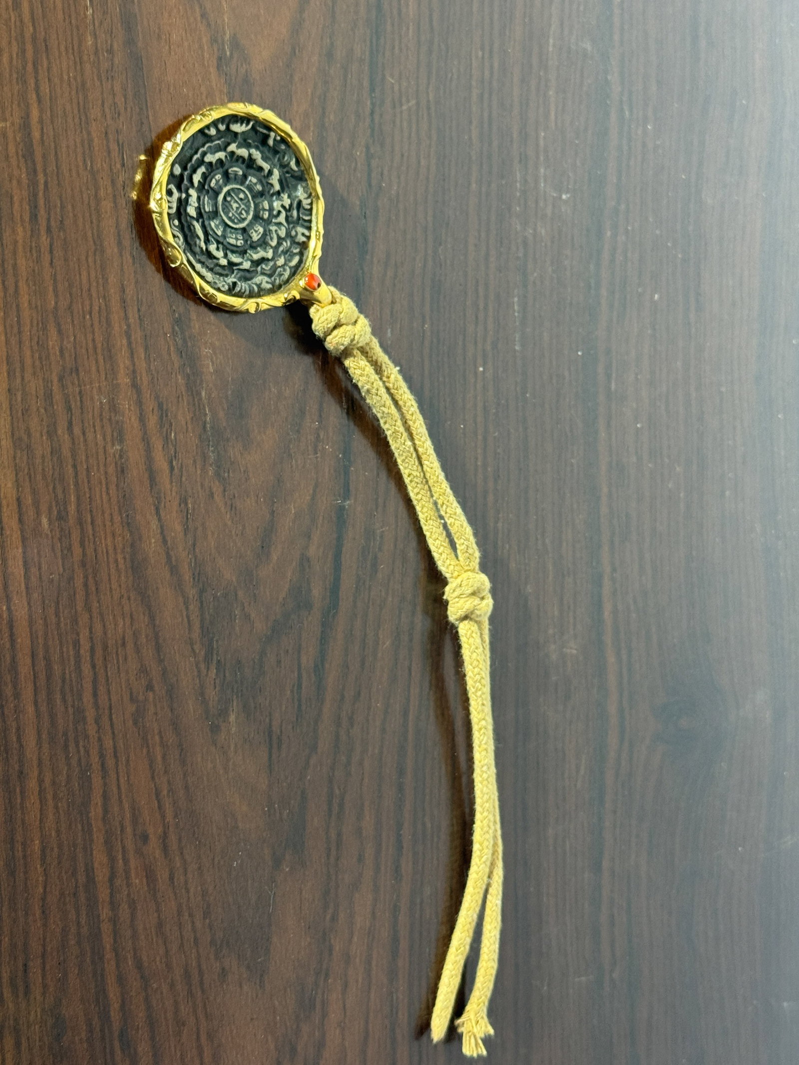TIBETAN BRASS ROUND BAGUA PENDANT: Tibetan round brass Bagua pendant with rope. Dimensions: Diameter: 1.75 in. (4.4 cm). Note: This item is in New York, where it can be shipped from.