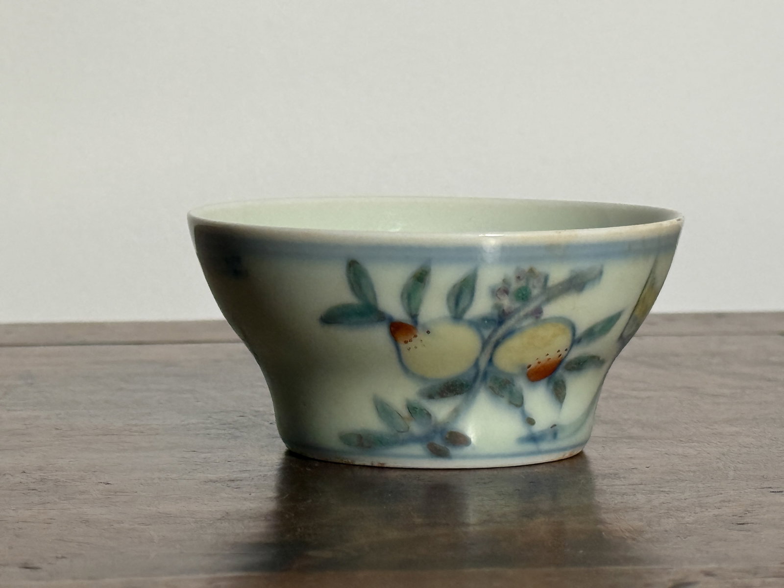CHINESE DOUCAI CUP: Chinese doucai cup with Chenghua mark and peach motif. Kiln fissure. Dimensions: Diameter: 3.25 in. (8.3 cm); Height: 1.7 in. (4.3 cm). Note: This item is in New York, where it can be shipped from.