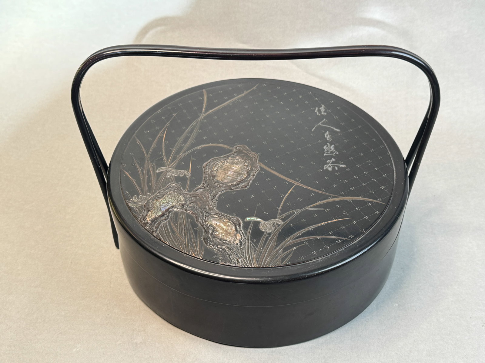JAPANESE MEIJI LACQUER BOX WITH HANDLE: Japanese black lacquer box with handle, mother-of-pearl inlay, and raised silver lacquer calligraphy, Meiji period. Dimensions: Height: 15 in. (38.1 cm). Note: This item is in New York, where it can b