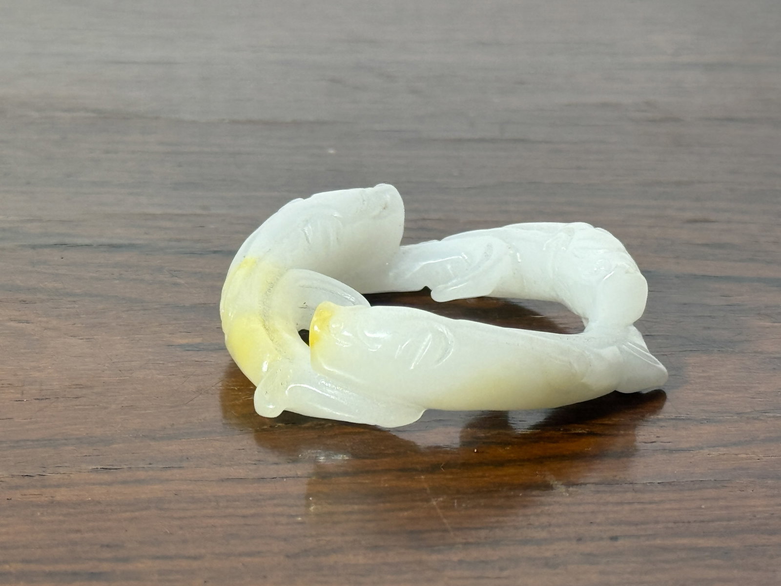 CHINESE CARVED JADE THREE-FISH RING: Chinese carved jade ring formed by three fish. Dimensions: Diameter: 2.5 in. (6.3 cm). Note: This item is in New York, where it can be shipped from.