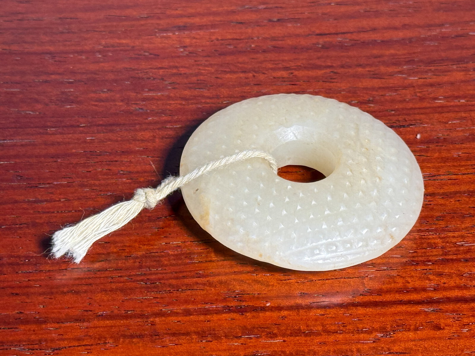 SMALL CHINESE JADE BI WITH DOTS: Small Chinese jade bi with dots. Dimensions: Diameter: 2 in. (5.1 cm). Note: This item is in New York, where it can be shipped from.