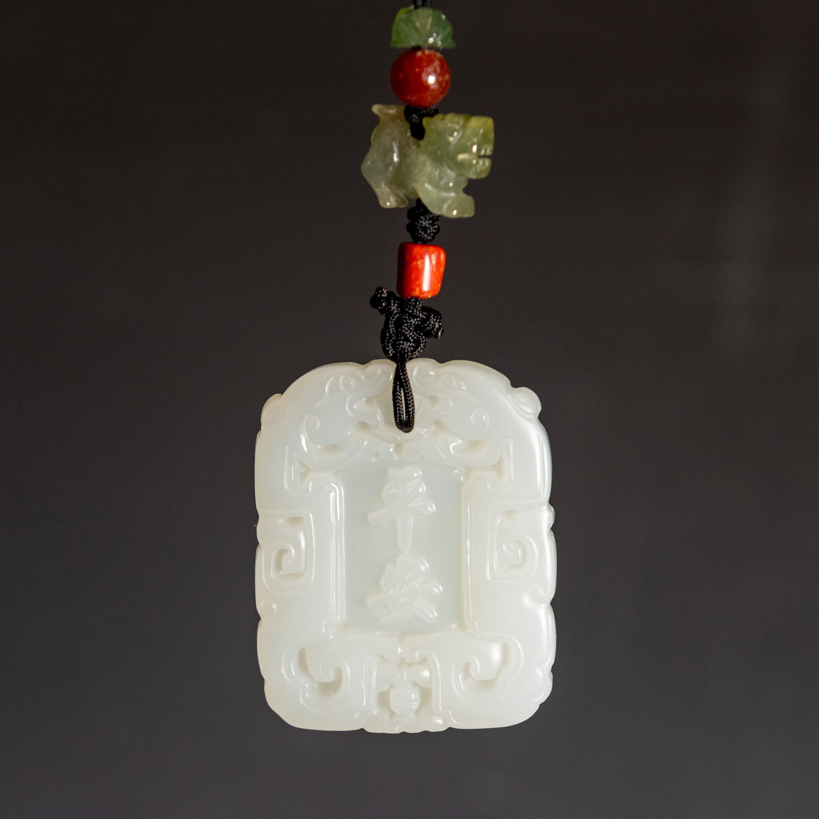 A CHINESE CARVED WHITE JADE PLAQUE: A Chinese carved white jade plaque. 1.85"h x 1.46"w x 0.24"l (4.7 x 3.7 x 0.6 cm) Provenance: Property from a San Francisco private collection.