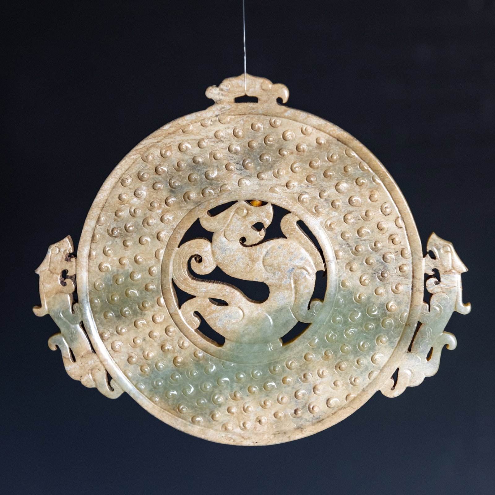 A CHINESE 'CHILONG' JADE BI DISC: A Chinese 'chilong' jade bi disc. 12 x 10.5 cm