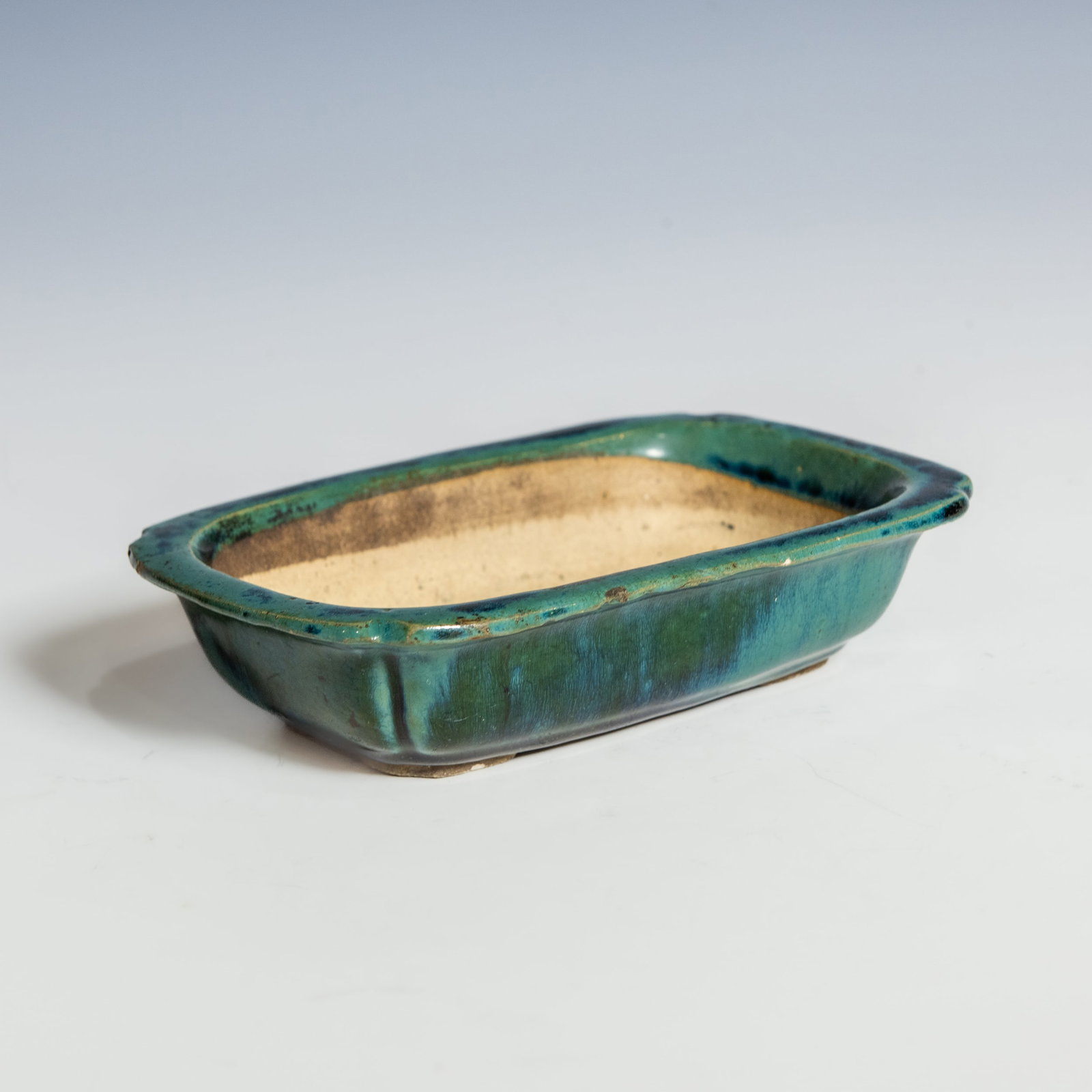 A SHIWAN TURQUOISE-GLAZED RECTANGULAR VESSEL WITH MARK, QING DYNASTY: A Shiwan turquoise-glazed rectangular vessel with mark, Qing dynasty. The rectangular vessel is finished with a rich turquoise glaze to the exterior, pooling to darker tones along the sides, and left 