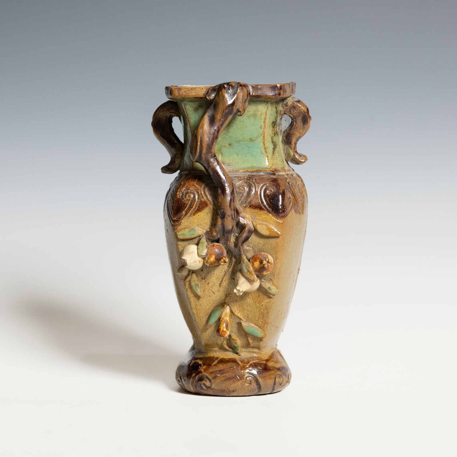 A CHINESE SHIWAN GLAZED POTTERY VASE, REPUBLIC PERIOD: A Chinese Shiwan glazed pottery vase, Republic period. The baluster-form vase is applied in high relief with a gnarled tree trunk bearing blossoms and foliage, the body covered in a variegated brown, 