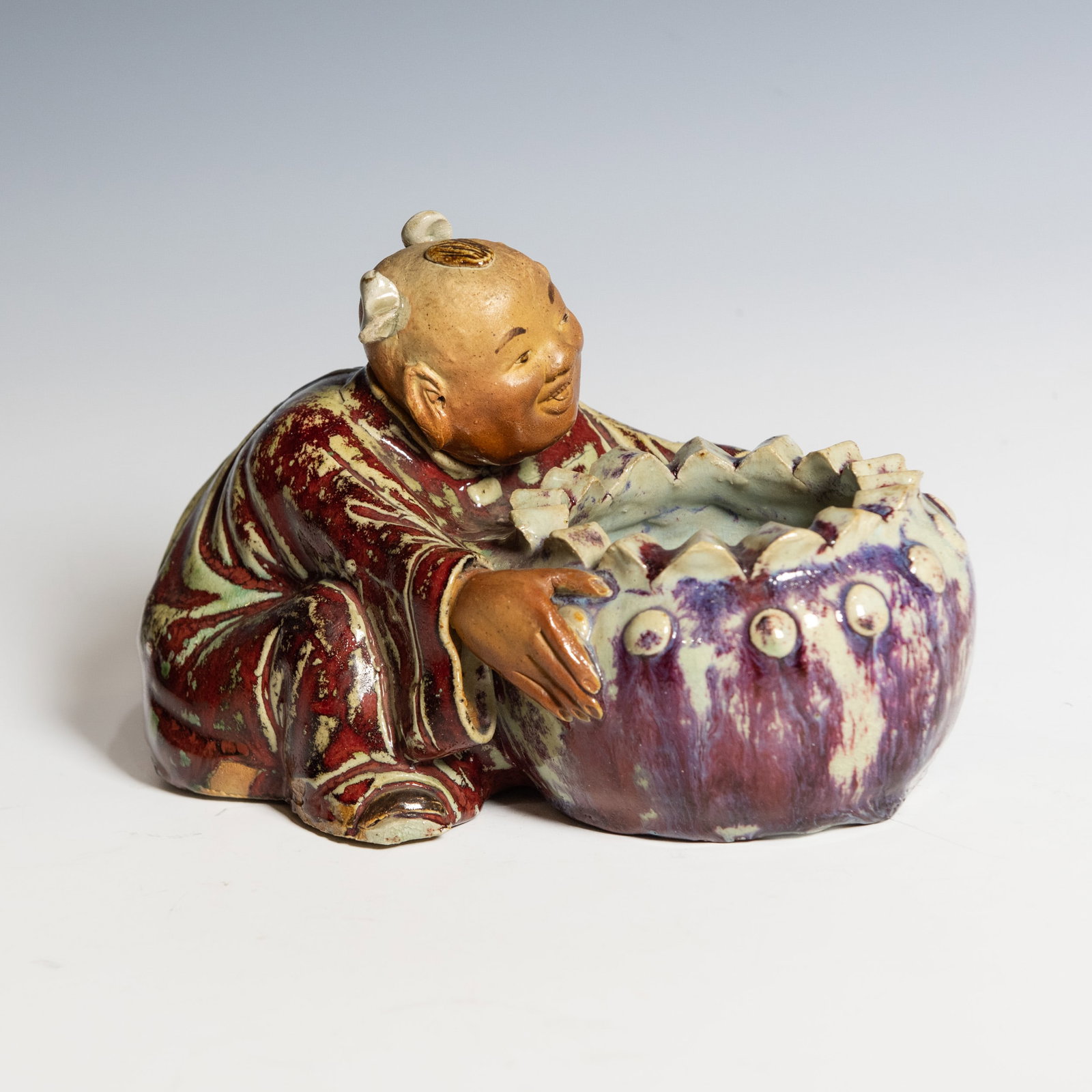 A SHIWAN GLAZED FIGURE OF A POMEGRANATE BOY WITH MARK, QING DYNASTY (1 of 13)