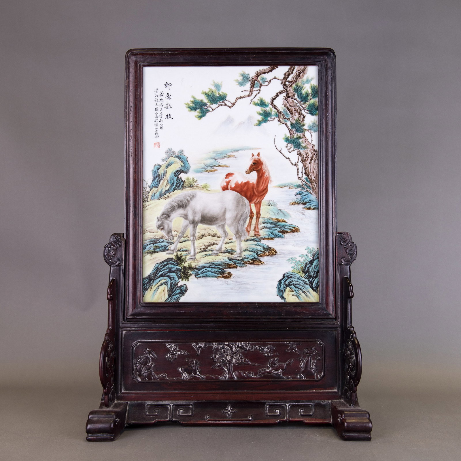 ZHANG ZHITANG (1893-1971), FAMILLE-ROSE 'HORSE' TABLE SCREEN, EARLY 20TH CENTURY: Zhang Zhitang (1893-1971), famille-rose 'horse' table screen, early 20th century. The porcelain panel is decorated with a white and a brown horse by a riverside, mounted in wood with a wooden stand. 2