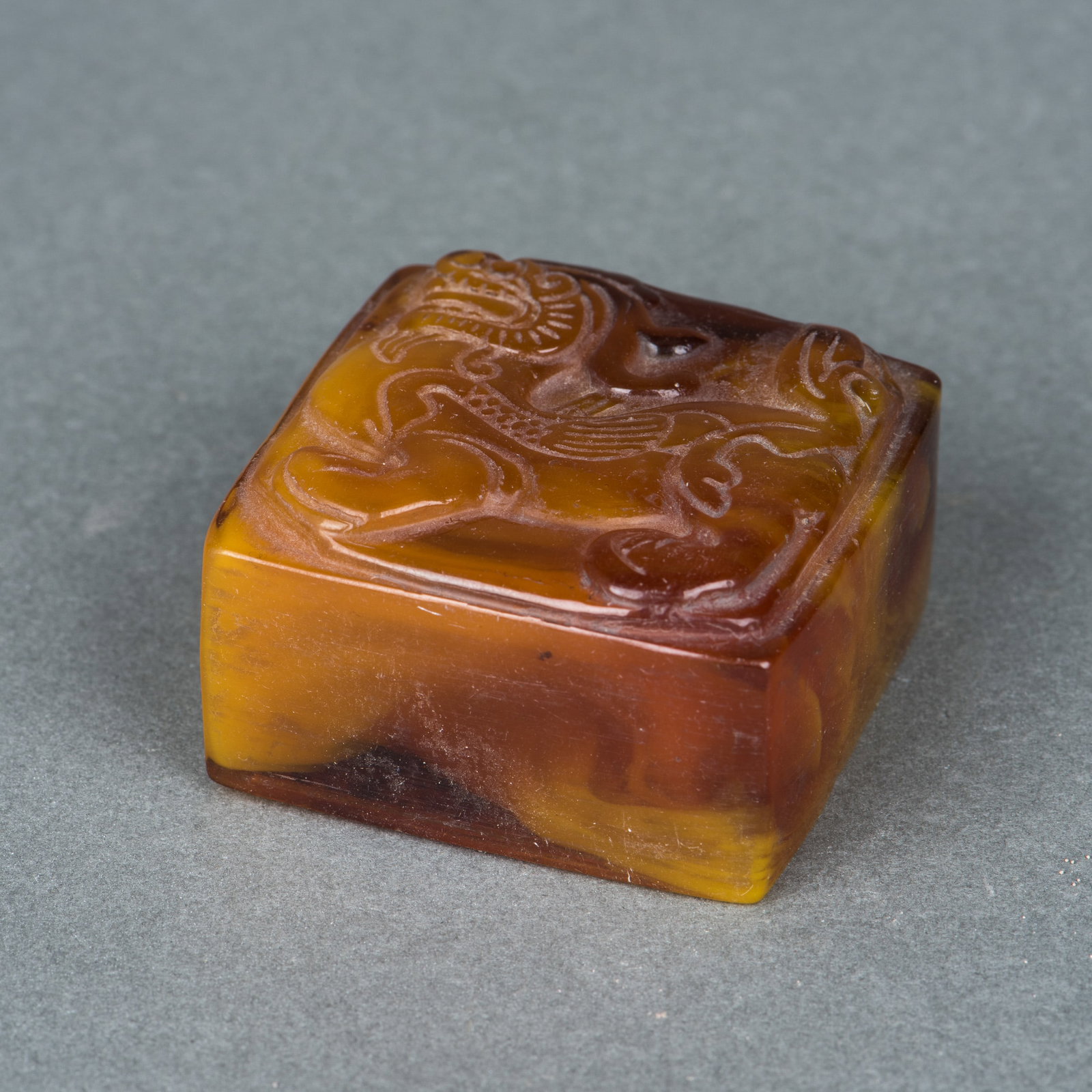 AN AMBER 'MYTHICAL BEAST' SEAL: An amber 'mythical beast' seal. 2.5 x 4 x 4 cm