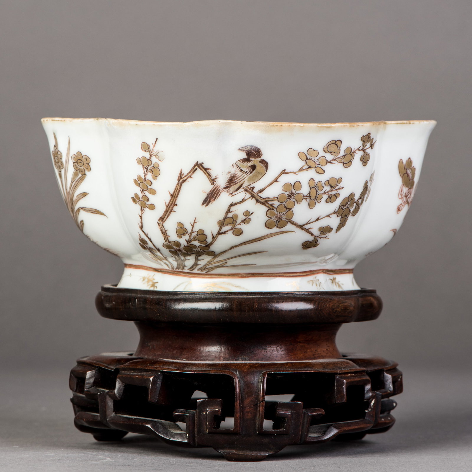 CHINESE GILT 'FLORAL AND BIRD' BOWL WITH HARDWOOD BASE, 19TH CENTURY: Chinese gilt 'floral and bird' bowl with hardwood base. The bowl rises from a slightly spreading foot to a flared rim and is decorated around the exterior in gilt with a floral-and-bird pattern. A