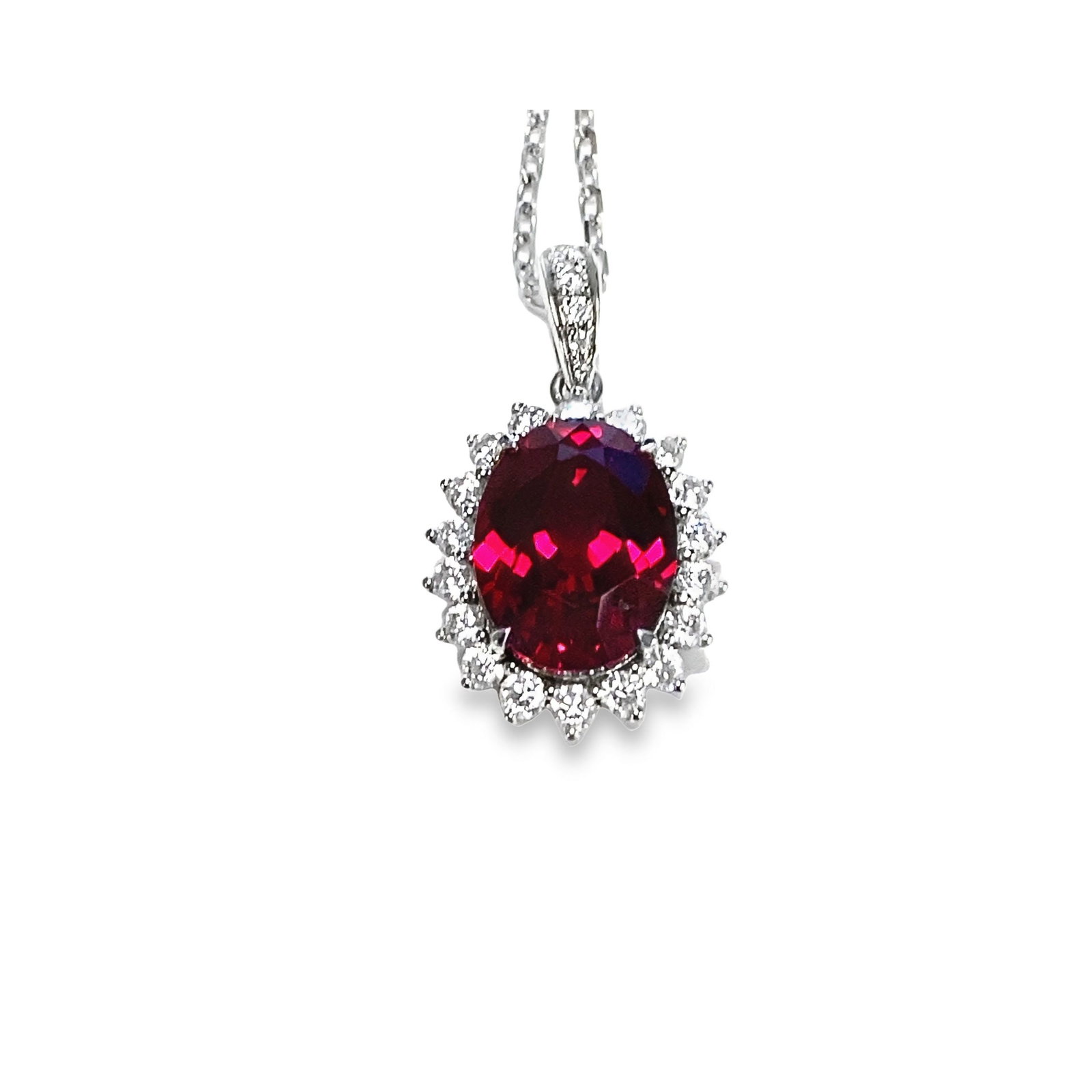 LAB RUBY AND DIAMOND PENDANT NECKLACE OVER STERLING SILVER: Lab ruby and diamond pendant necklace over sterling silver, centering an oval-shaped lab-grown ruby framed by lab-grown diamonds, with a chain. 2.6 gross dwt; Ruby: 3.25 carats