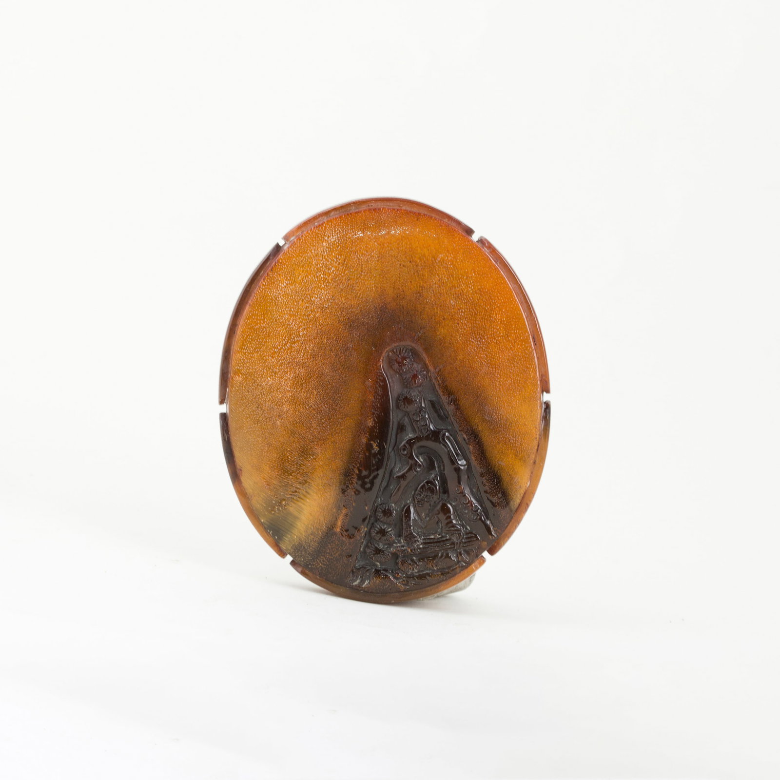 A PENDANT CARVED OF HORN: A pendant carved of amber-colored horn, finely carved and highly polished, with a different pattern on each side. 3.75"h x 0.5"w x 3"l
