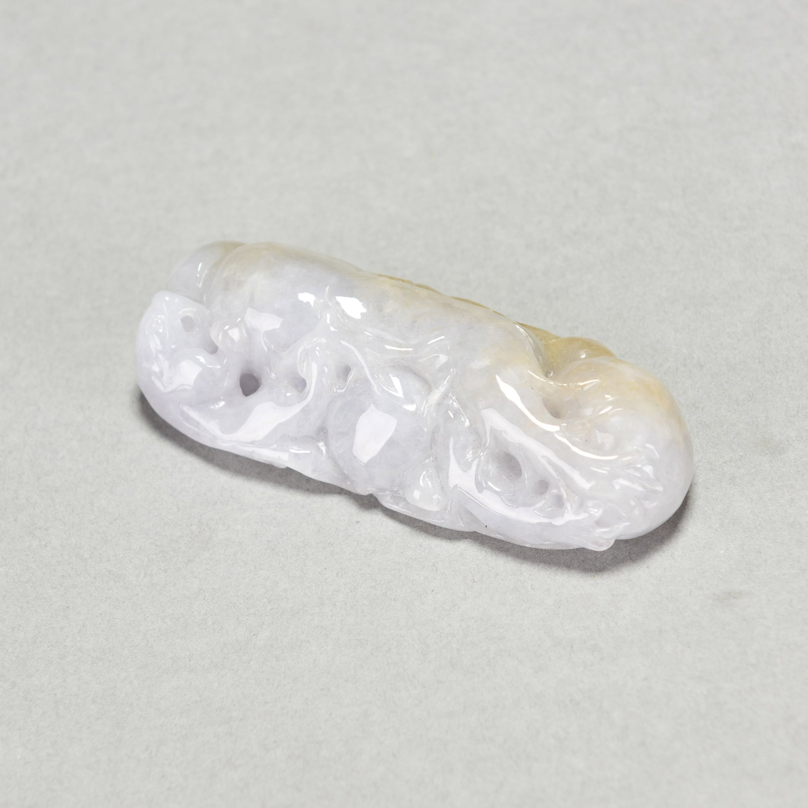 A CARVED LAVENDER JADEITE PENDANT: Carved lavender jadeite pendant. 3.15"h x 1.38"w x 0.79"l (8 x 3.5 x 2 cm); 58.2 dwt